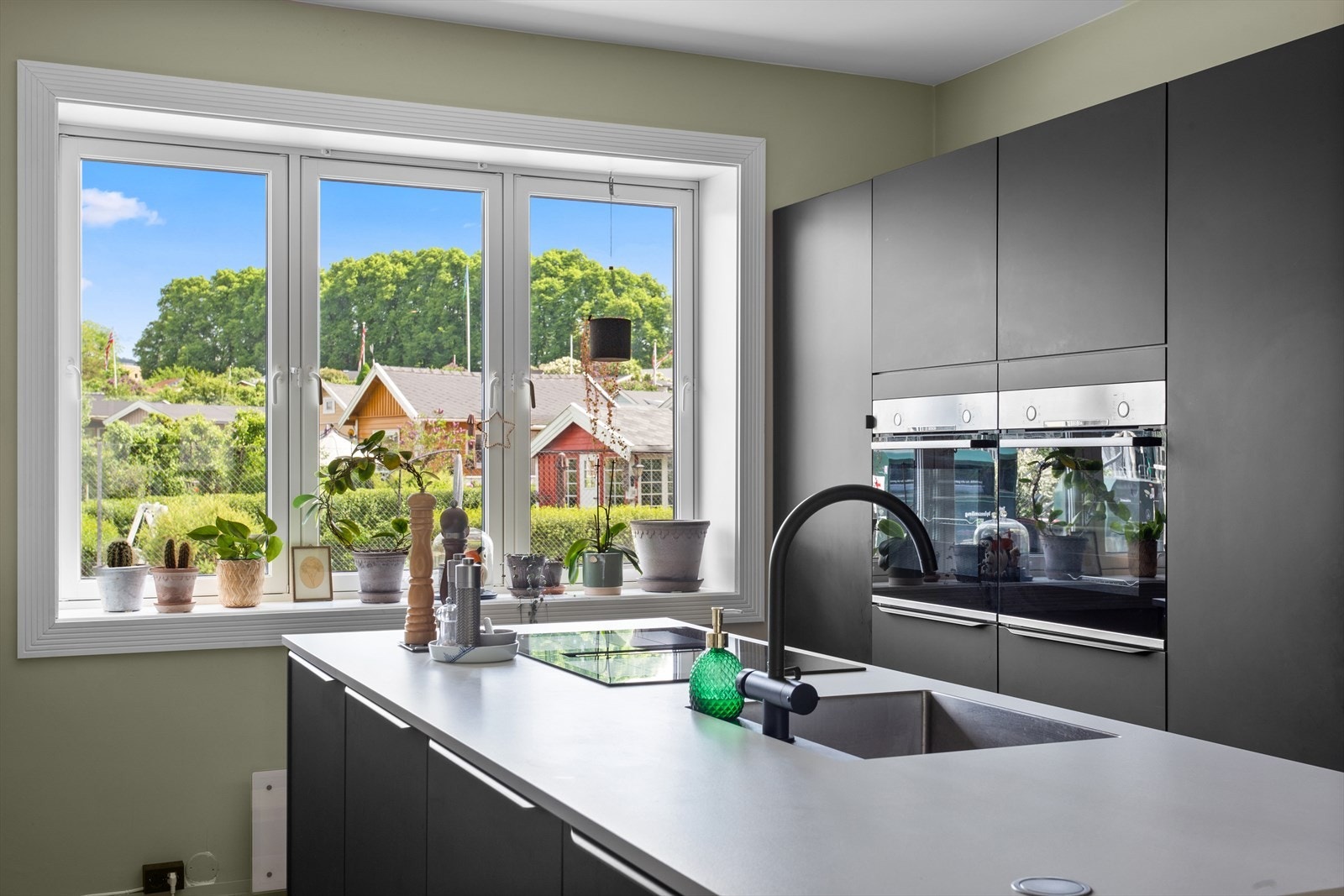 Lekkert kjøkken m/glatte fronter og frittstående kjøkkenøy. Integrert kjøleskap, fryser, oppvaskmaskin, 2 ovner og bred induksjonstopp med ventilator. Galleribilde