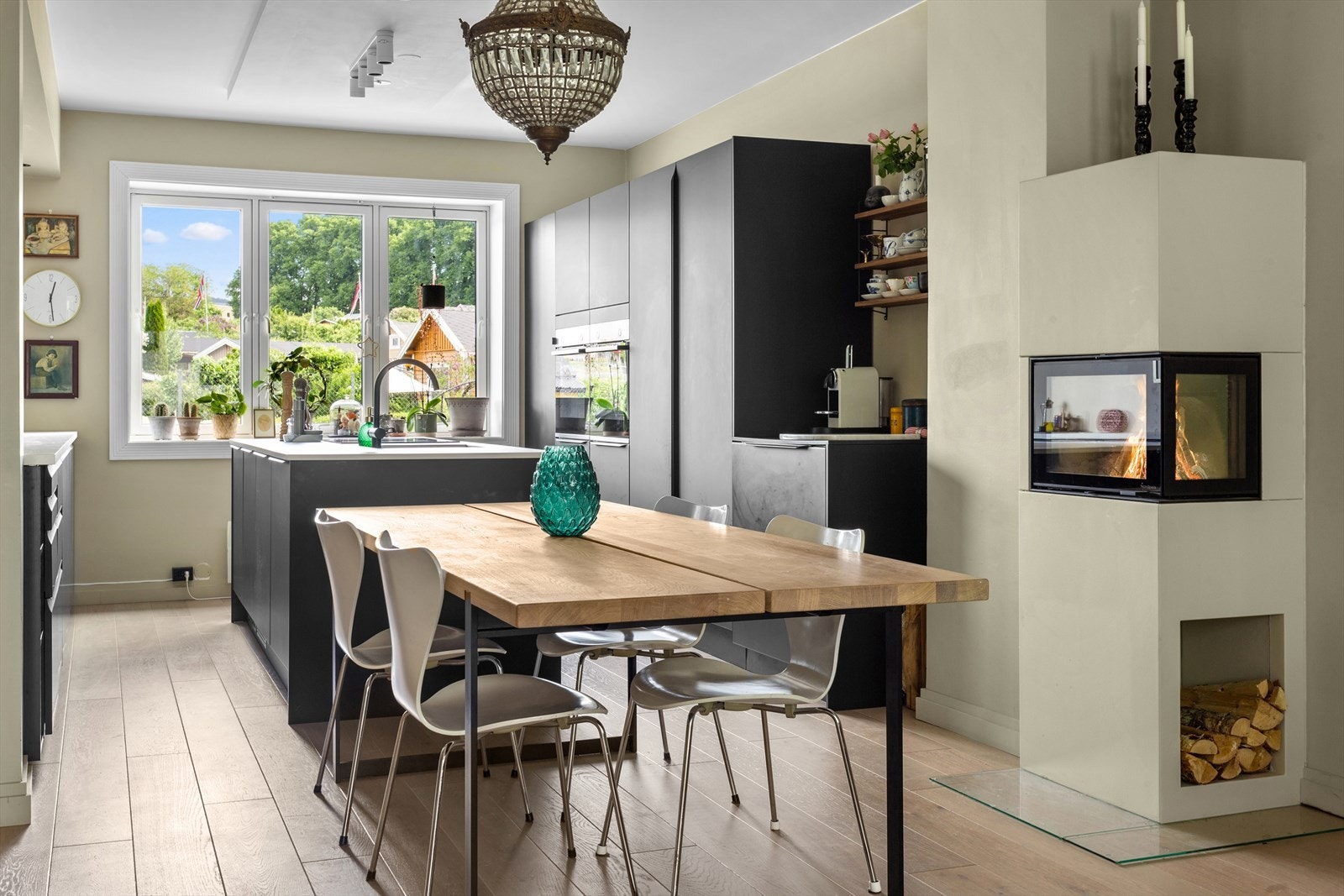 Ved spisestuebordet/kjøkken er det montert vinkelpeis med glassfronter Galleribilde