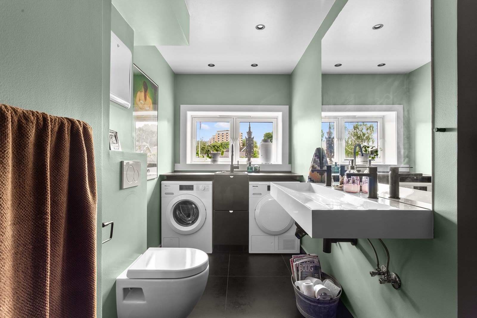 Badet er fra 2021 og har bl.a. veggmontert toalett og separat utslagsvask plassert foran vindu Galleribilde