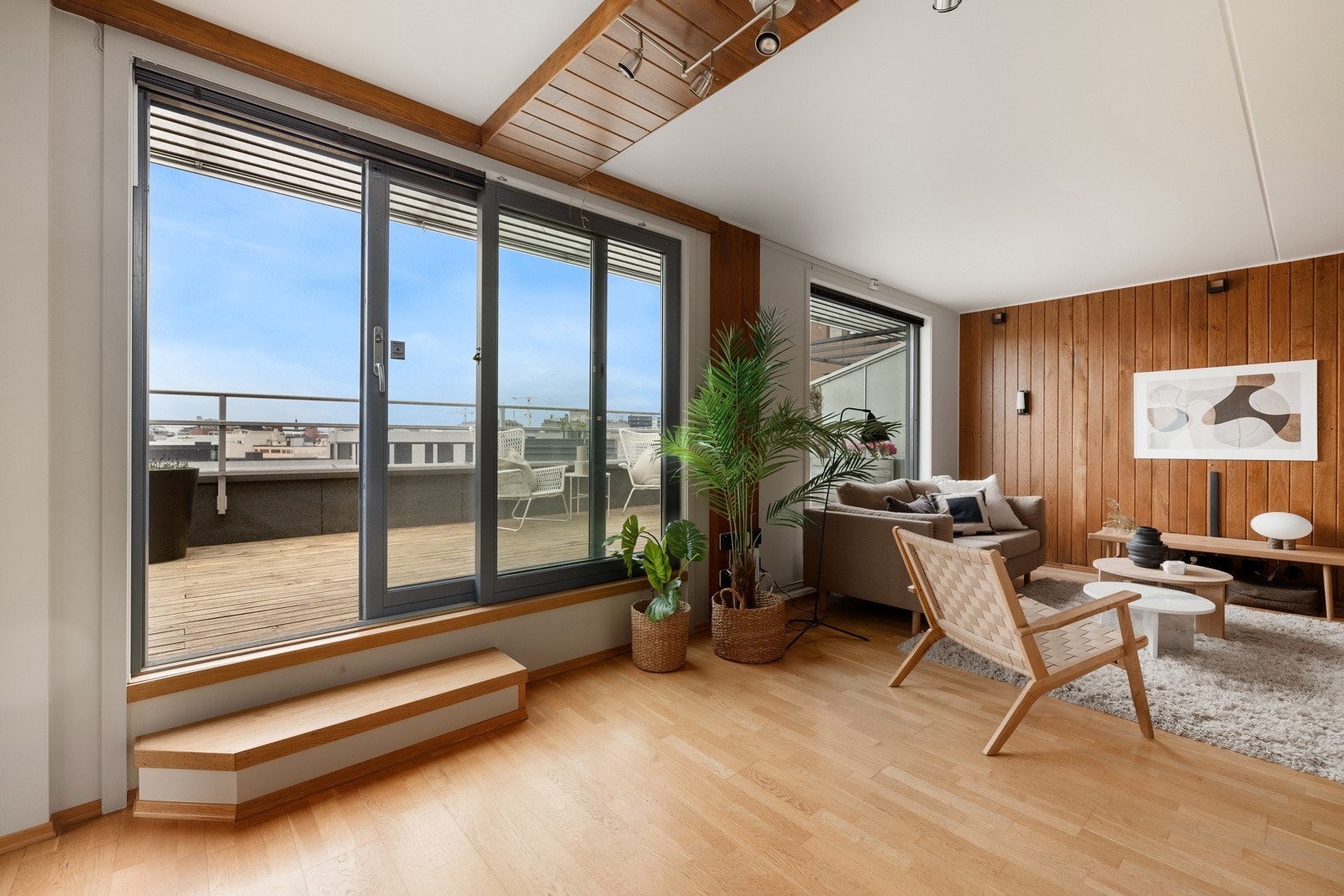 Stuen ligger usjenert plassert, og bades i dagslys fra panoramavindu og skyvedører ut til terrassen. Galleribilde