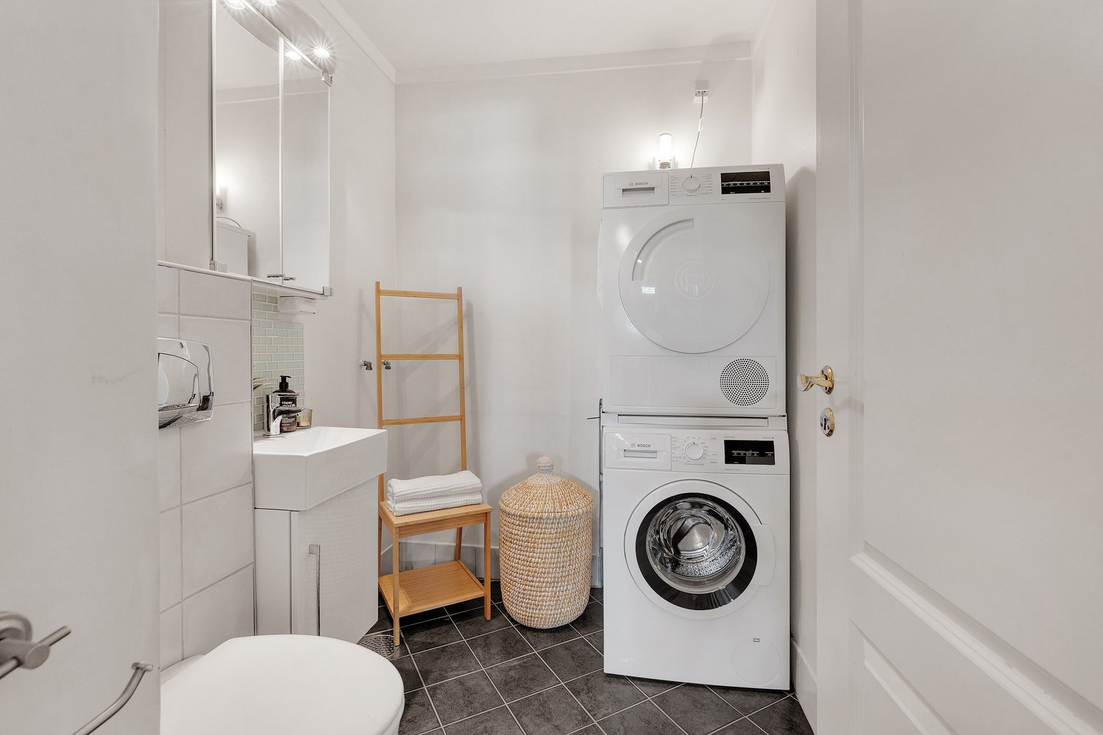 Praktisk vaskerom med flislagt gulv og gulvvarme. Tilrettelagt opplegg for vaskemaskin og tørketrommel. Galleribilde