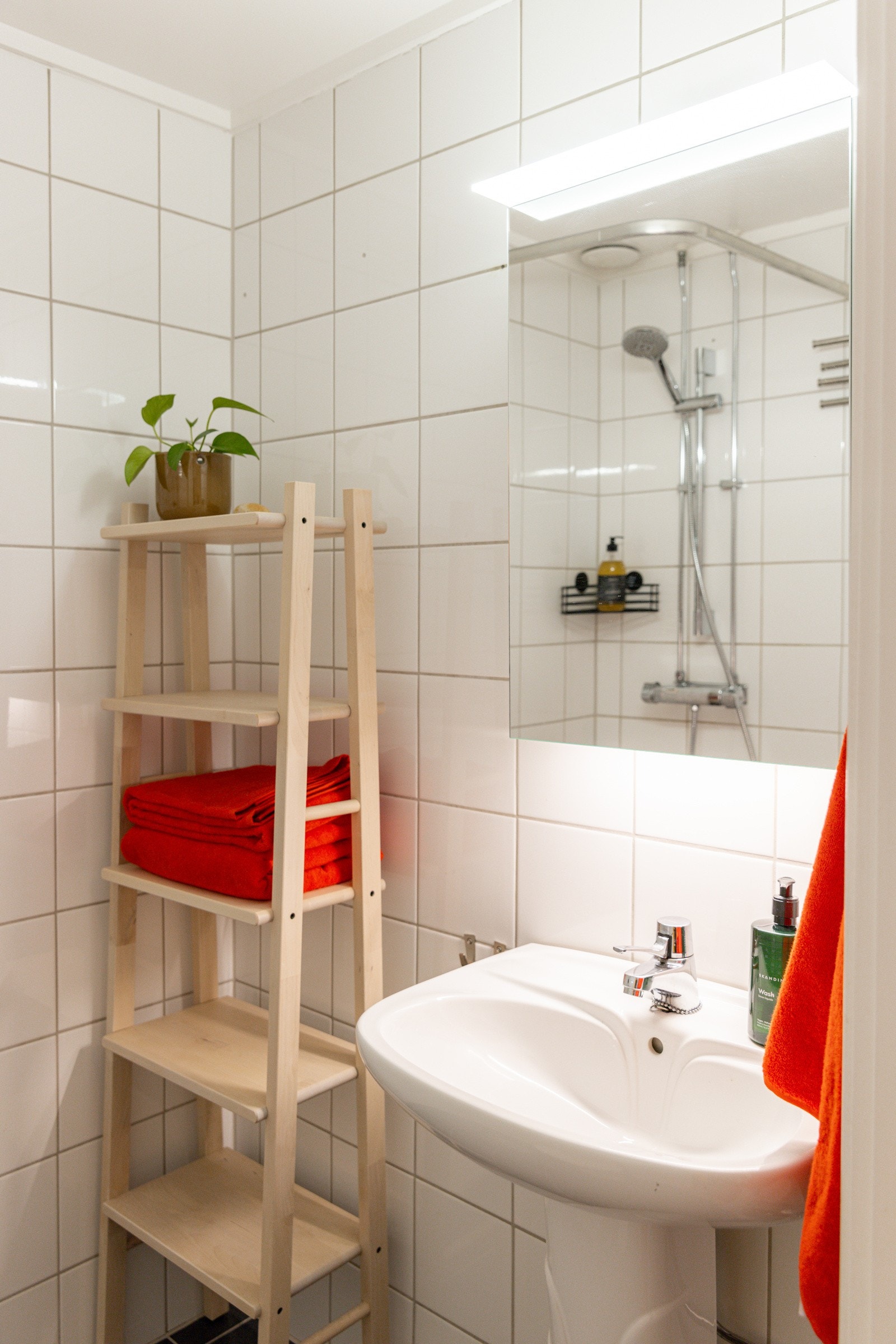 Baderommet er utstyrt med servant, speilskap med belysning, dusjhjørne med forheng og gulvstående toalett. Plass til vaskemaskin i hjørnet (det er også fellesvaskeri i kjeller i nabooppgangen). Galleribilde
