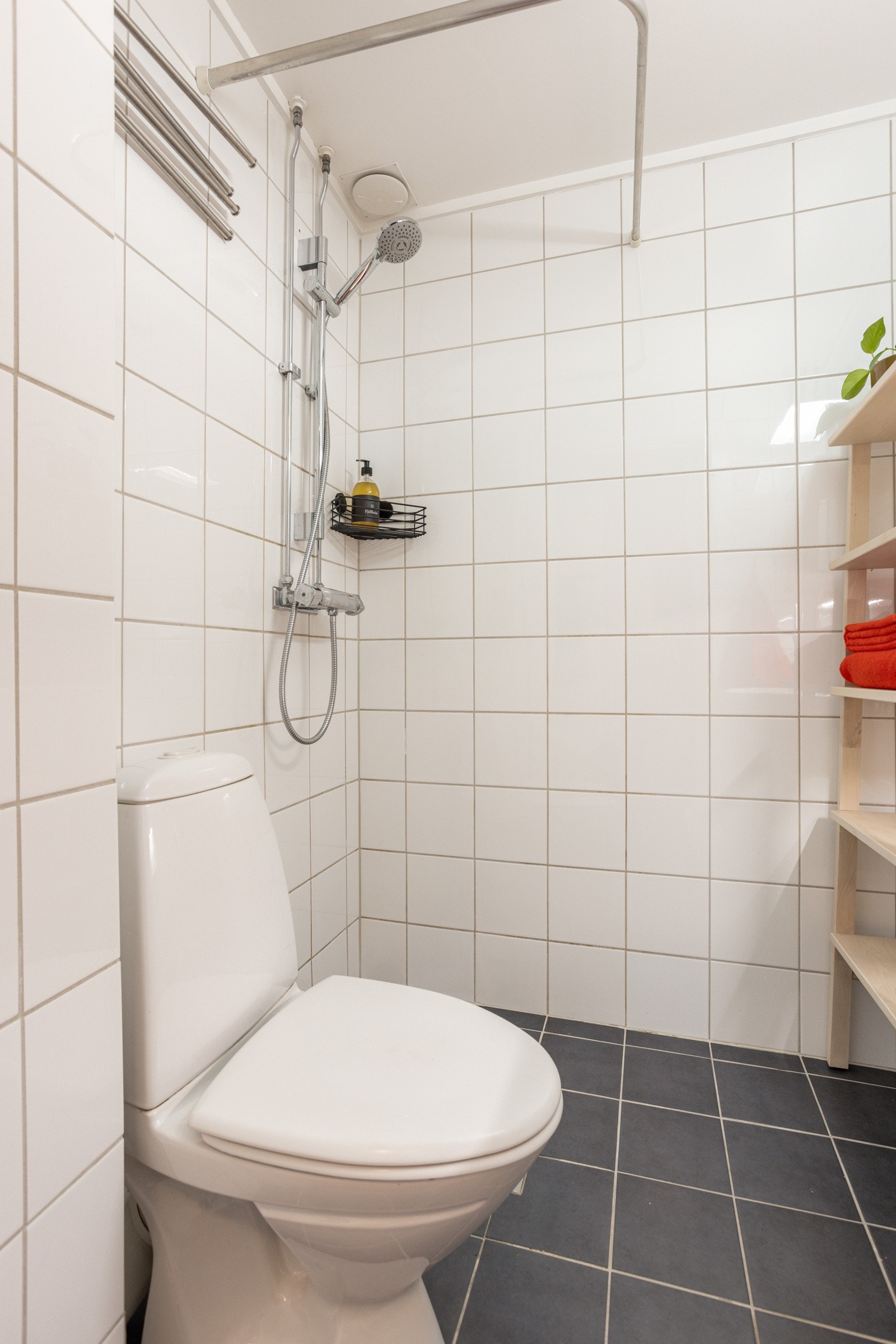 Baderommet har mørke fliser på gulv, deilig gulvvarme og hvite fliser på veggene. Galleribilde