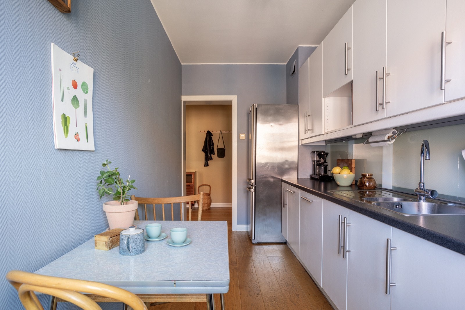 Pen og velholdt kjøkkeninnredning med god skap- og benkeplass. Innredningen har hvite glatte fronter og laminert benkeplate med nedfelt oppvaskkum. Galleribilde