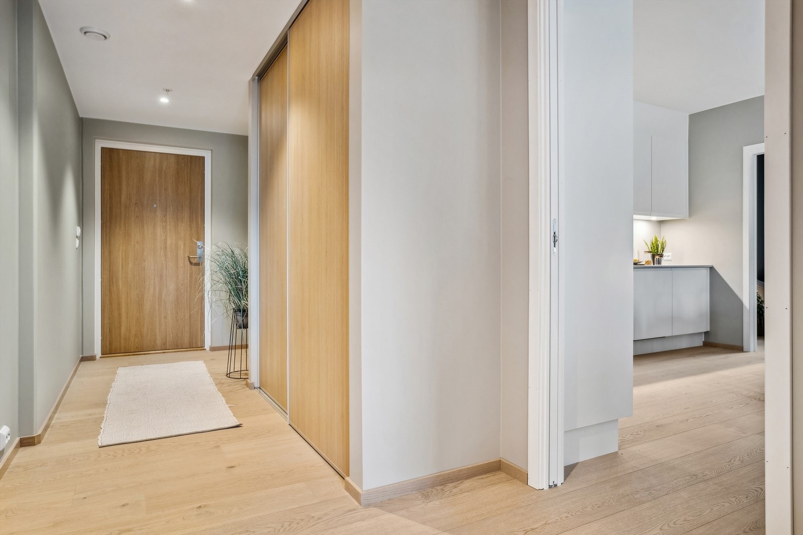 Romslig og innbydende gang med en praktisk skyvedørsgarderobe. Galleribilde
