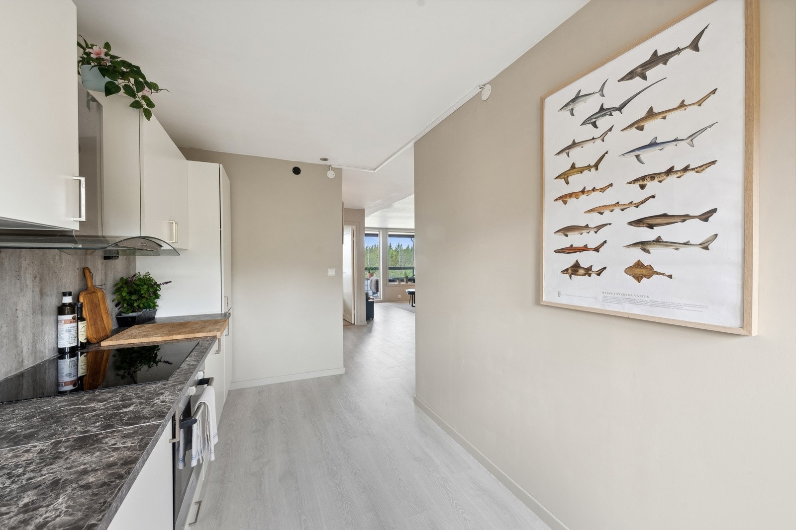 Kjøkkeninnredning med slette fronter, benkeplate av laminat, nedfelt oppvaskkum med ett-greps kran, kjøkkenplater mellom kjøkkenbenk og overskap. Galleribilde