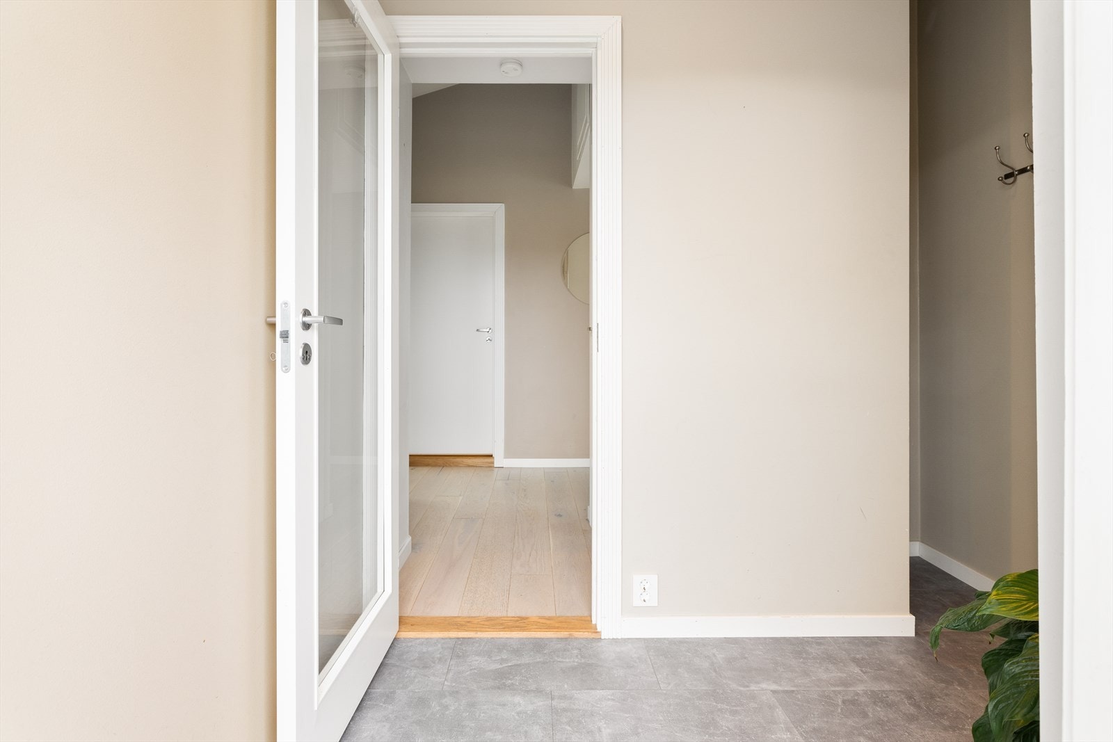 Romslig entré med laminatgulv, slette malte vegger og himling. Her er det plass til å henge fra seg yttertøy og sko. Galleribilde