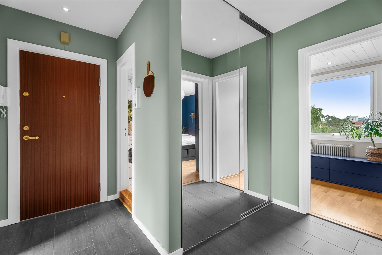 Entréen har en praktisk skyvedørsgarderobe med speilfronter, hvor yttertøy og sko kan oppbevares. Galleribilde