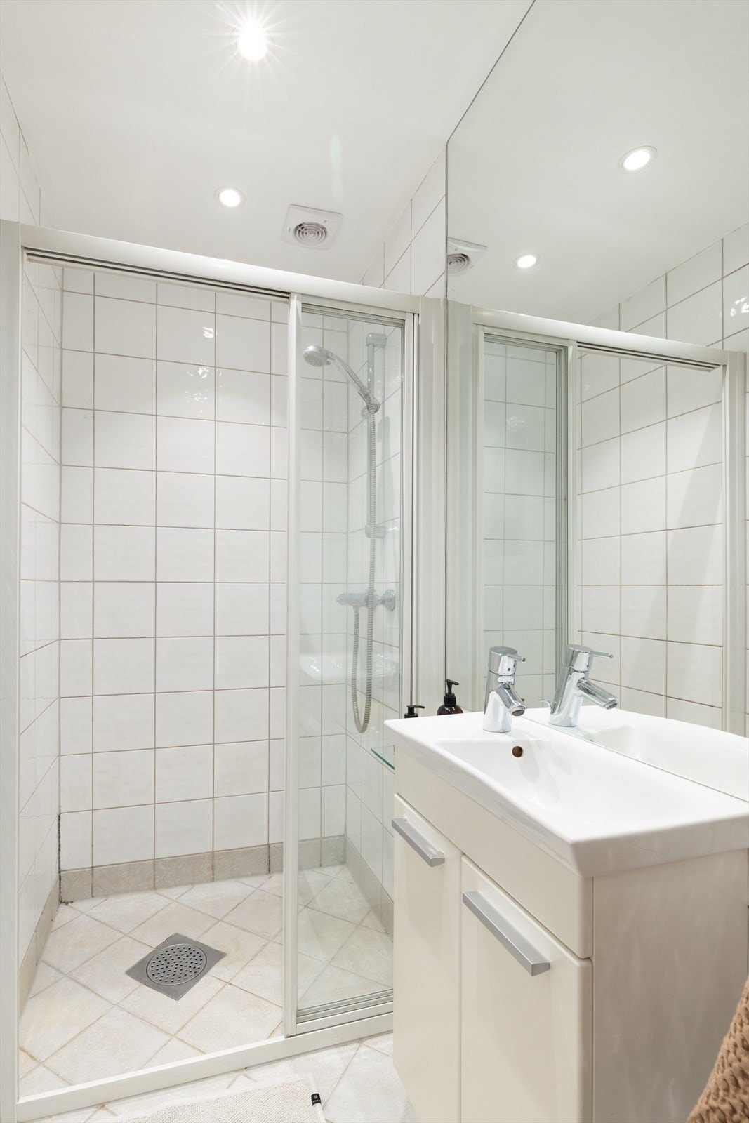 Badet er innredet med dusjhjørne og vegghengt toalett. Galleribilde