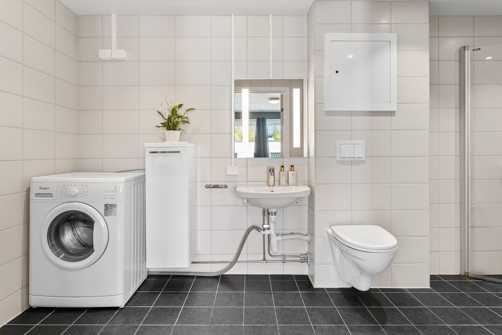 Badet har gulvvarme, downlights, flislagte overflater og opplegg for vaskemaskin. Galleribilde