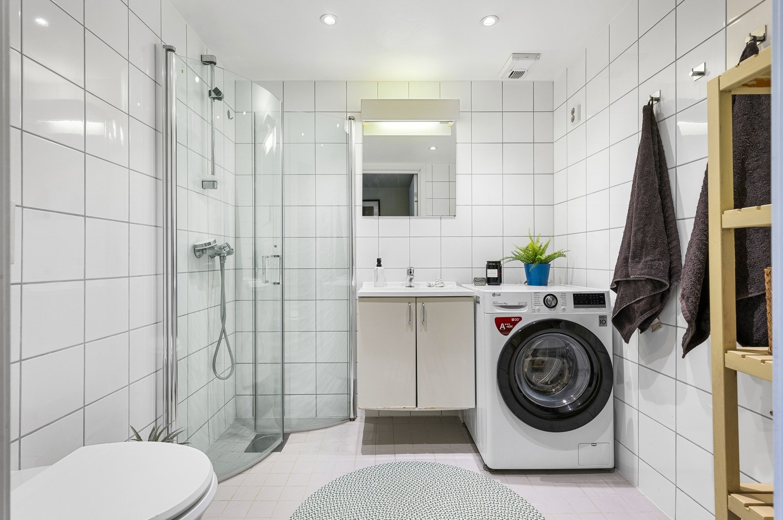 Lyst og pent flislagt bad med varme i gulv. Nedsenket himling med downlights. Galleribilde