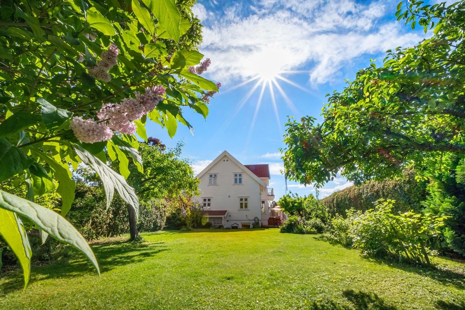 Solrik, idyllisk og pent opparbeidet tomt med stort hageareal med plen og beplantninger med skjermet beliggenhet Galleribilde