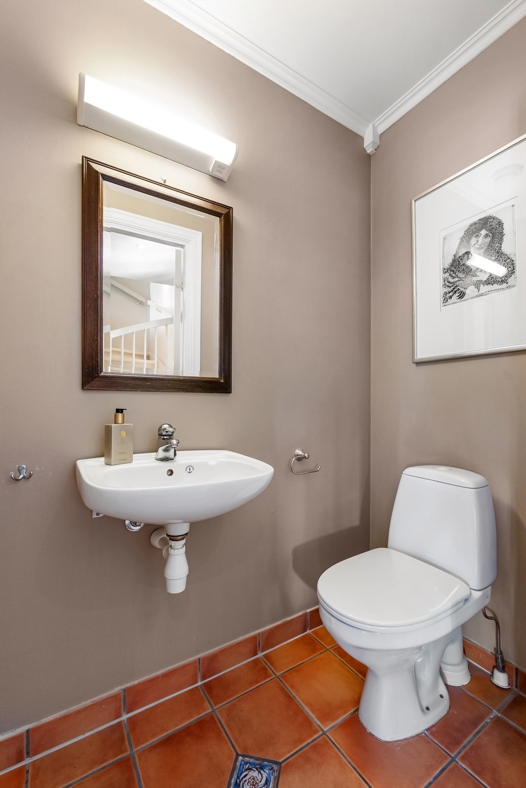 Toalettrom i 1.etg med flislagt gulv, gulvmontert toalett og servant Galleribilde