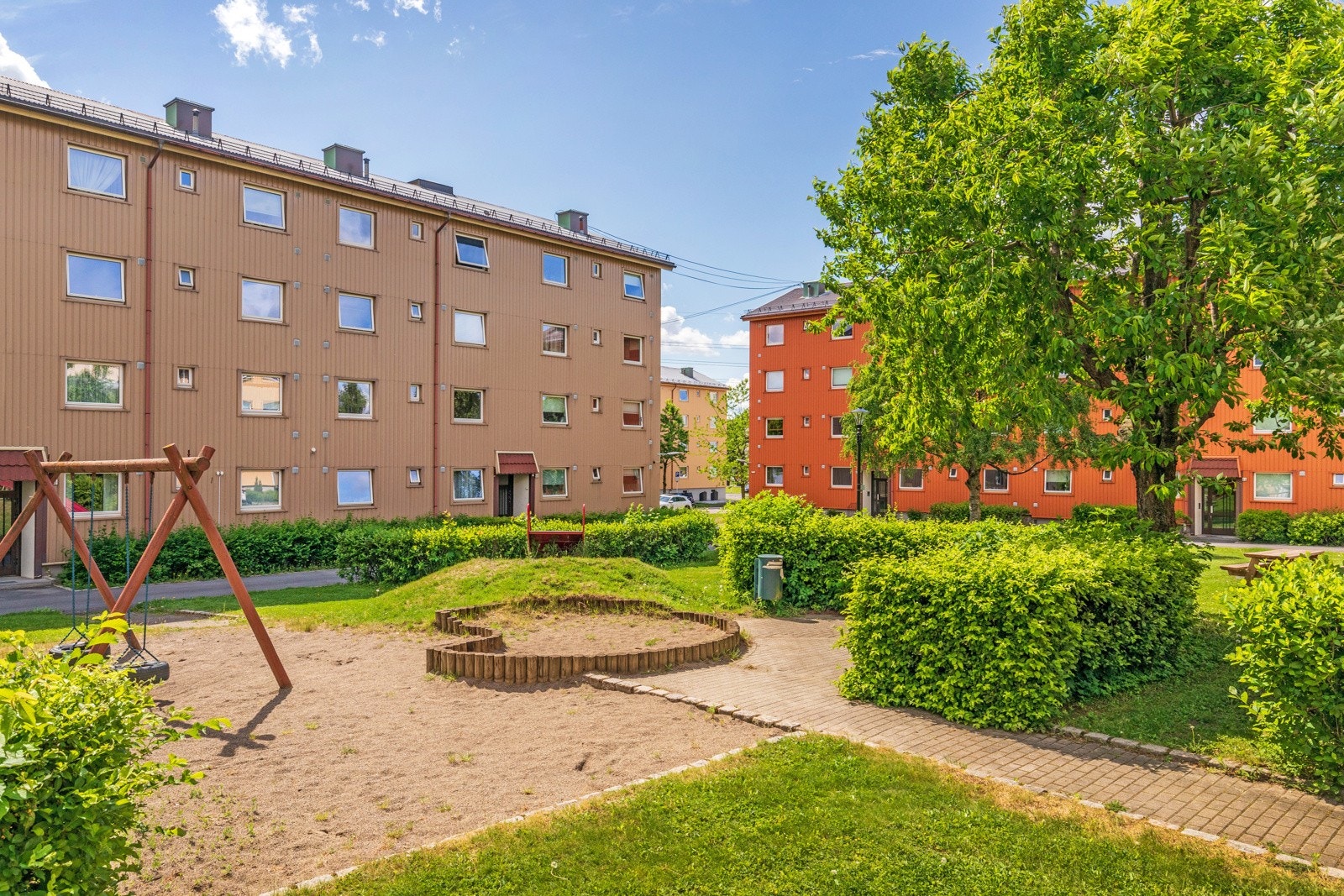 Pent opparbeidede felles grøntareal beplantet med trær, busker og øvrig beplantning. Lekeplass med sandkasser og lekeapparater. Galleribilde