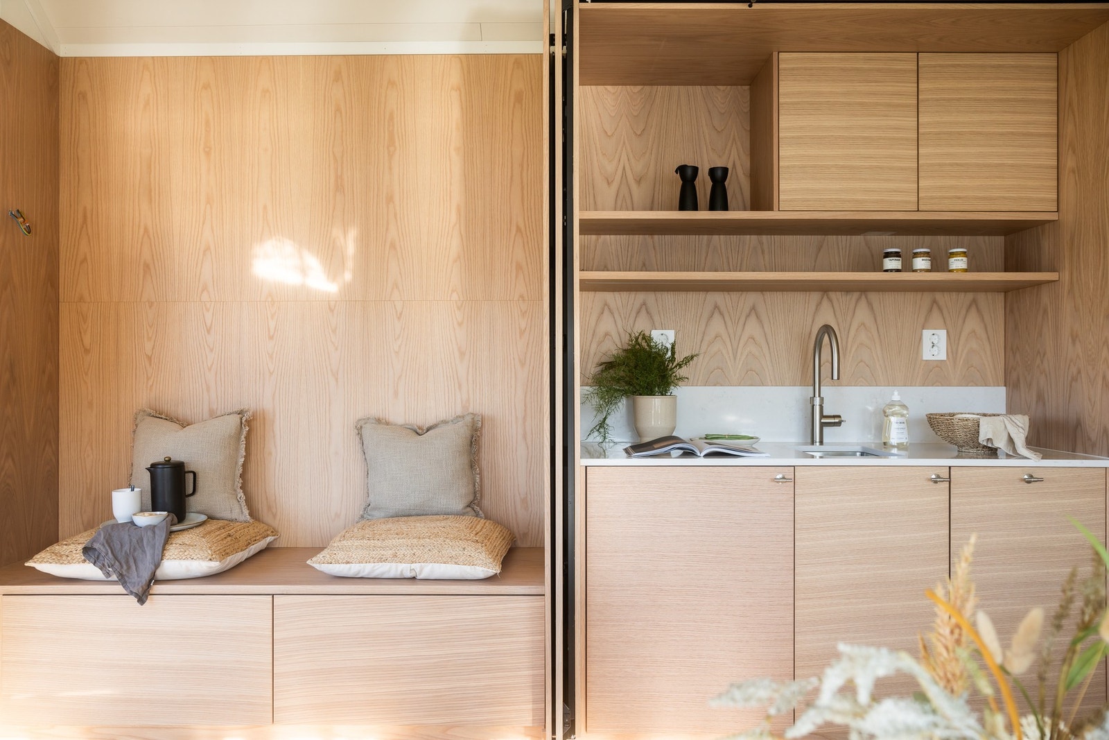 Moderne hybelkjøkken med tilhørende plassbygget sittebenk. Galleribilde