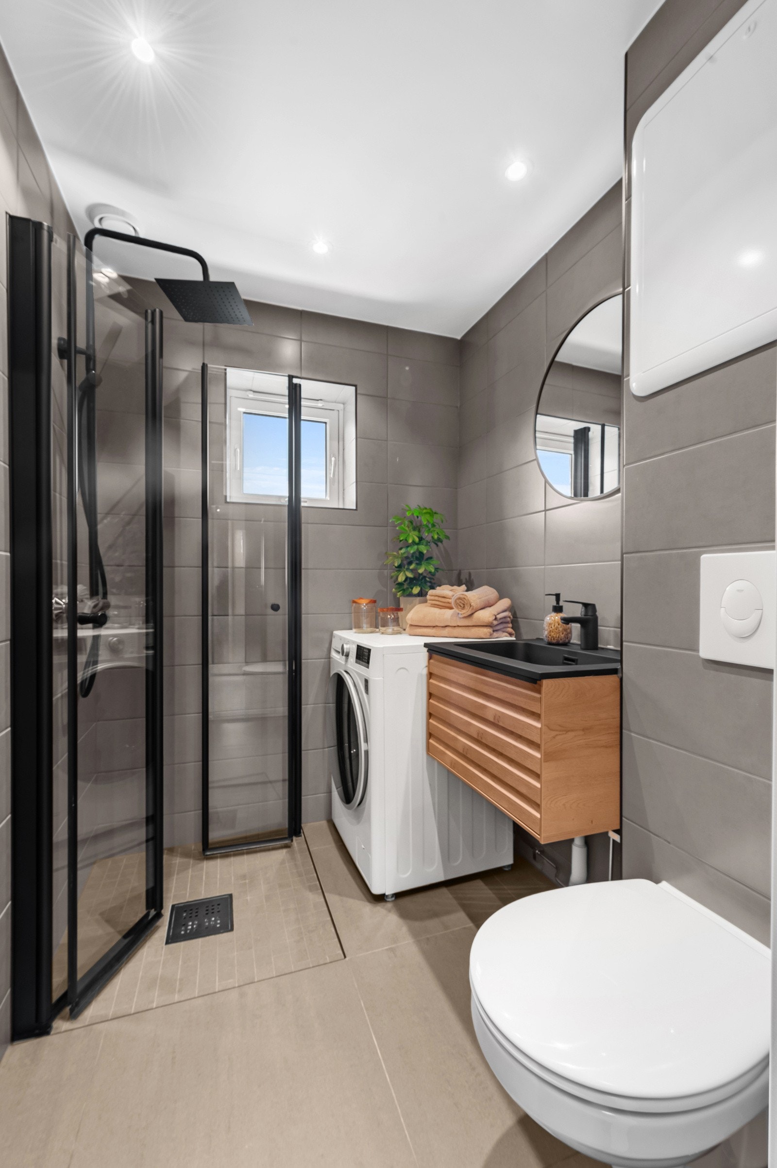 Baderomsinnredning med eikefronter gir et lunt uttrykk. Opplegg for vaskemskin. Galleribilde