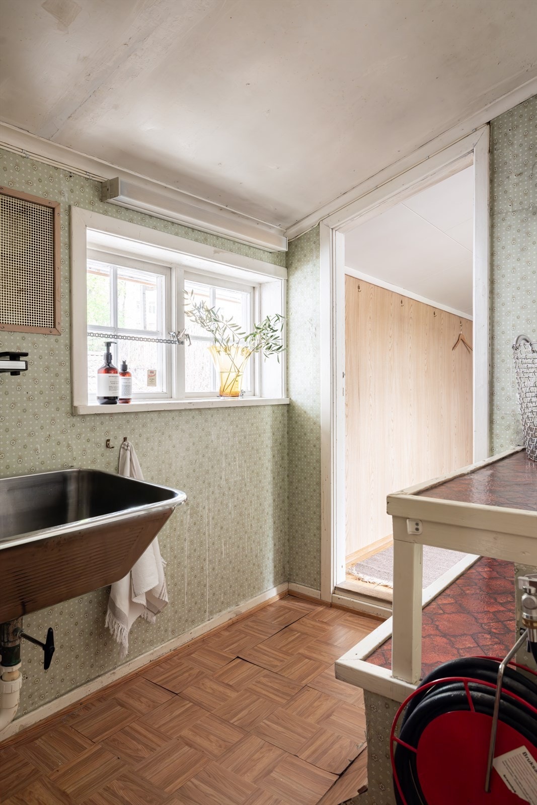 Mellomgang med utslagsvask og opplegg for vaskemaskin. Rommet har ikke sluk. Galleribilde