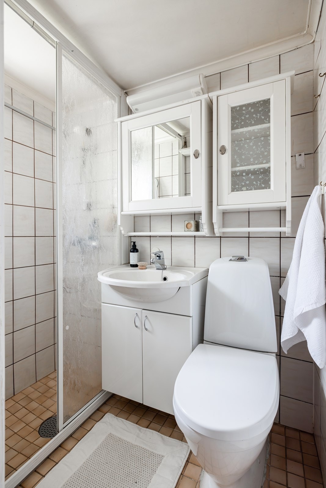 Dette eldre badet har flislagte overflater og er innredet med heldekkende servant på underskap, speilskap og belysning. Badet har en dusj, klosett, og har fått TG3 i tilstandsrapporten på grunn av alderen. Galleribilde