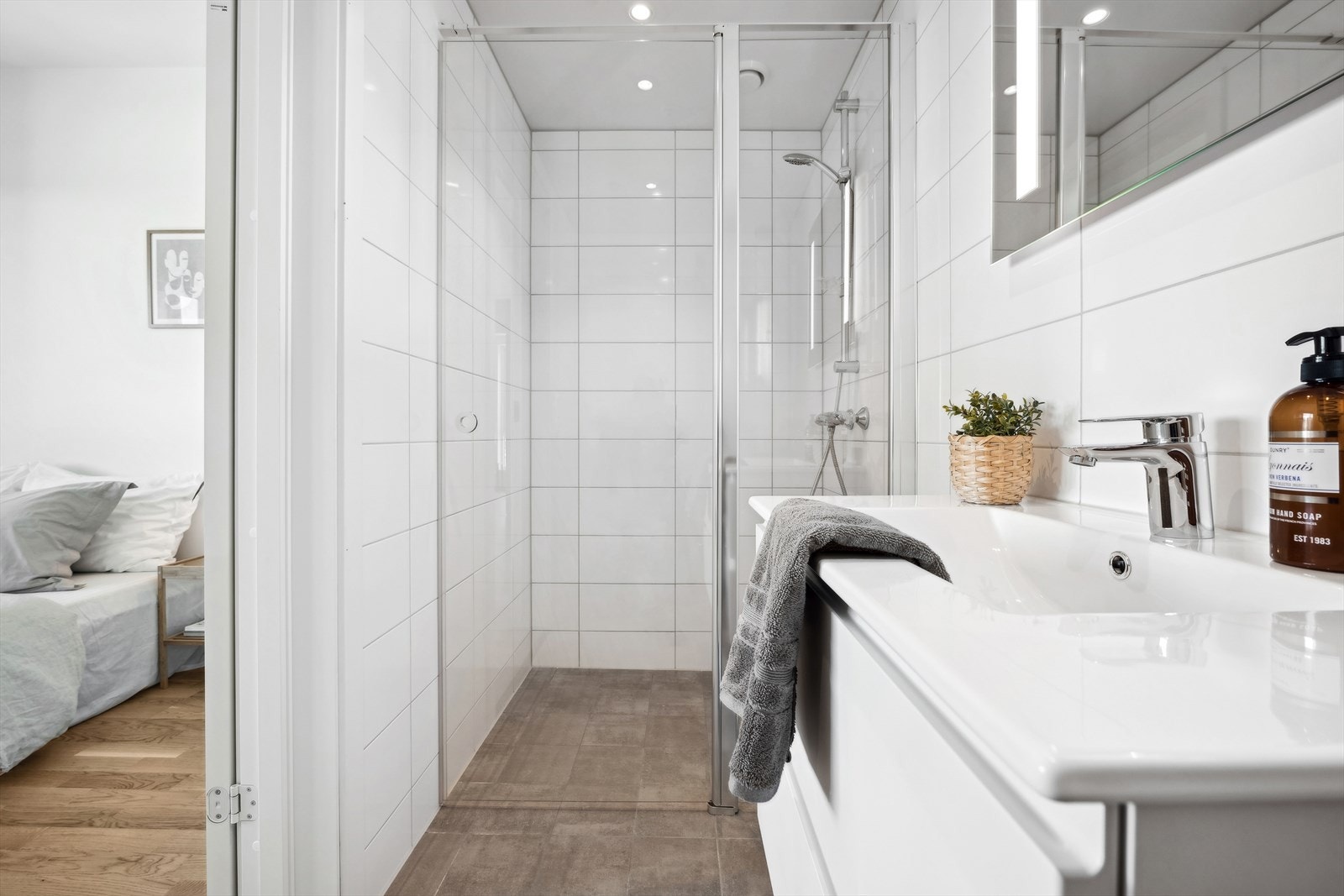 Tidløst baderom innredet med dusjnisje, servant og klosett. Fjernvarme i gulv. Galleribilde