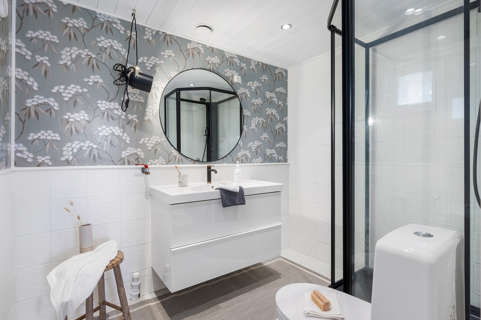 Badet har fliser på gulv og vegger. Det er også spotter i tak. Galleribilde