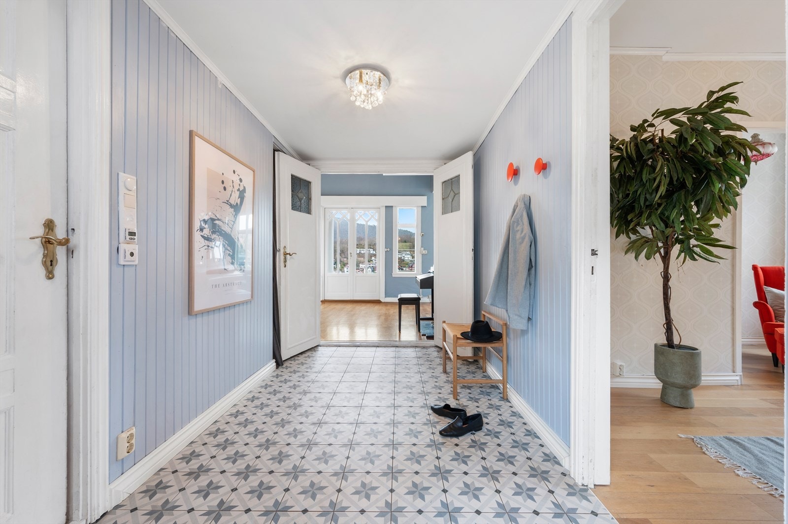 Velkommen inn! Her blir vi møtt av en romslig entré, med god plass til oppbevaring av klær og sko. Det er og plass til annet møblement. For ekstra komfort er gangen flislagt med varmekabler i gulv. Galleribilde