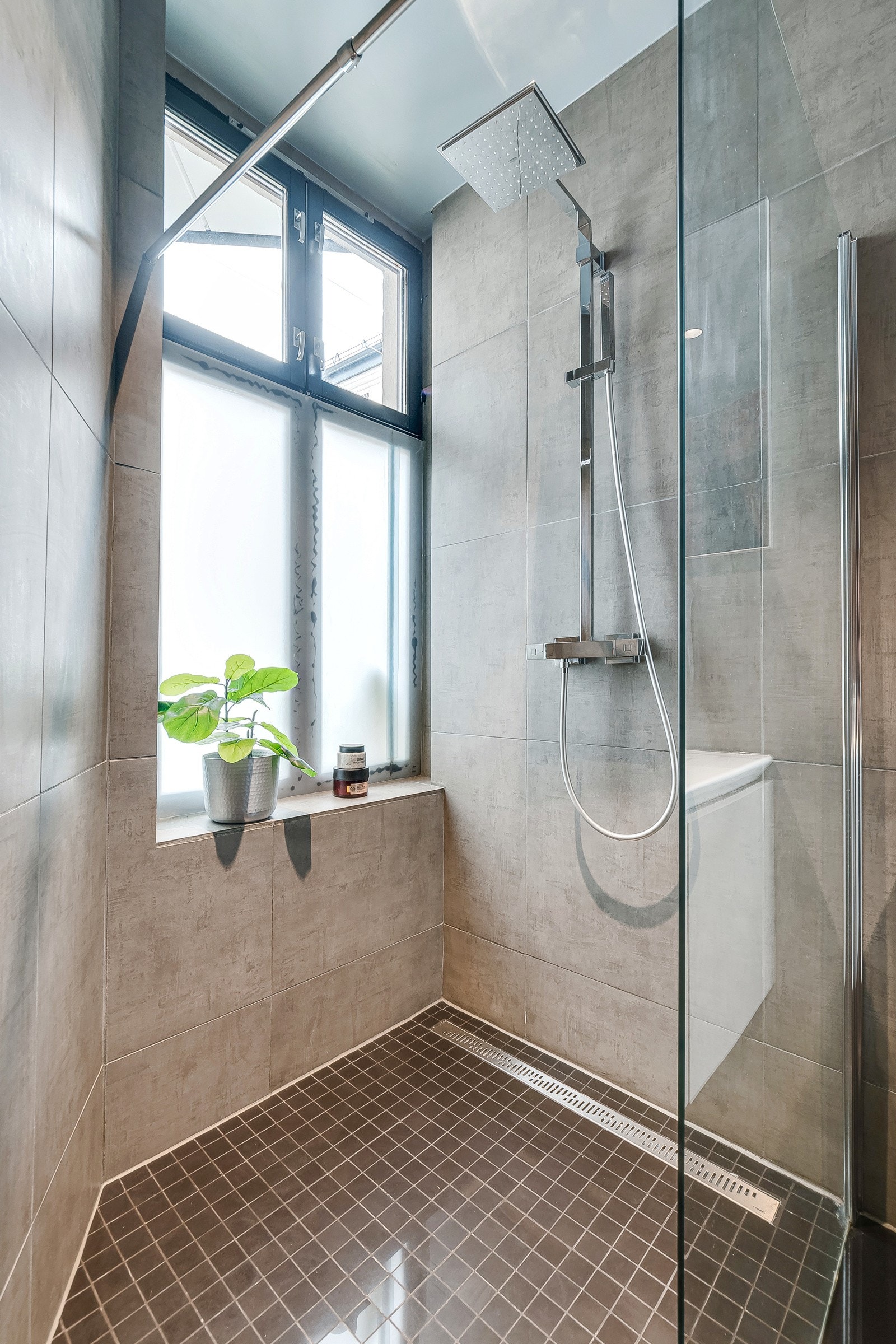 Stor dusjnisje med glassvegg og flotte mosaikkfliser på gulvet. Galleribilde