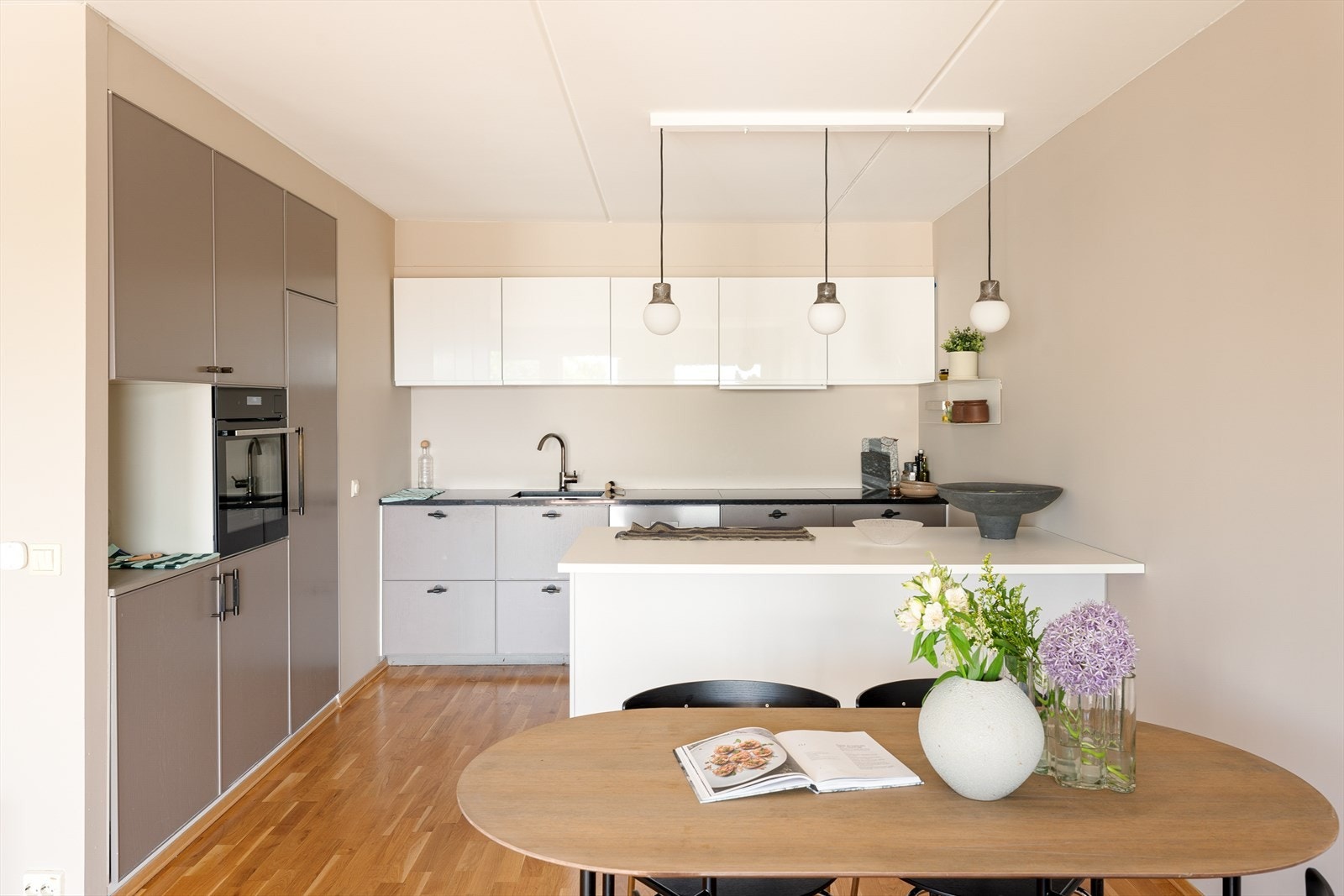 Et stilrent kjøkken med god benke- og skapplass, samt en kjøkkenøy med mulighet for barkrakker under. Galleribilde