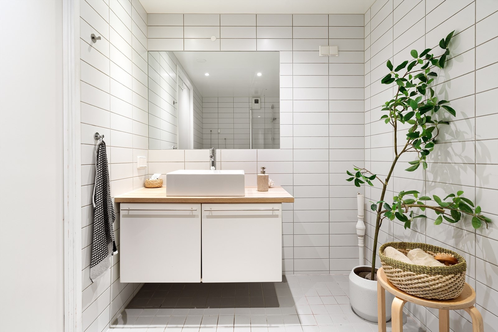 Det flislagte badet har lys innredningen som inkluderer en servant fra 2024 med ett-greps blandebatteri. Dusjdørene ble byttet ut i 2022. Galleribilde