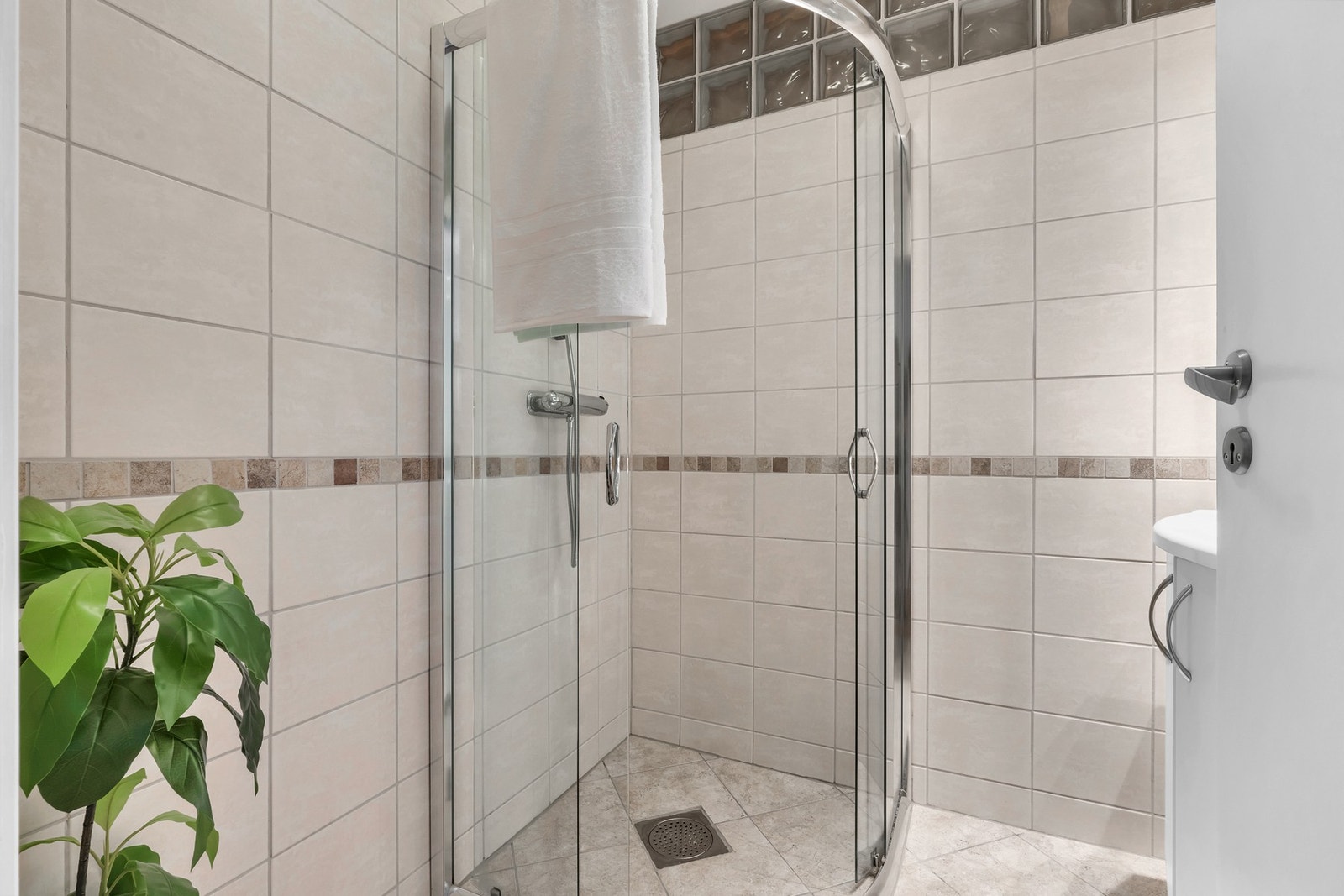 Dusjhjørne med glassdører. Badet har byttet plass med vaskerommet, slik at man nå har et større bad enn originalt. Galleribilde