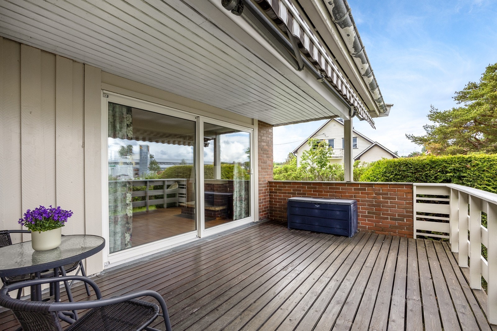 Eiendommen har solrike uteområder og uteplasser. Fra stuen er det utgang til denne delvis, overbygde terrassen. Galleribilde