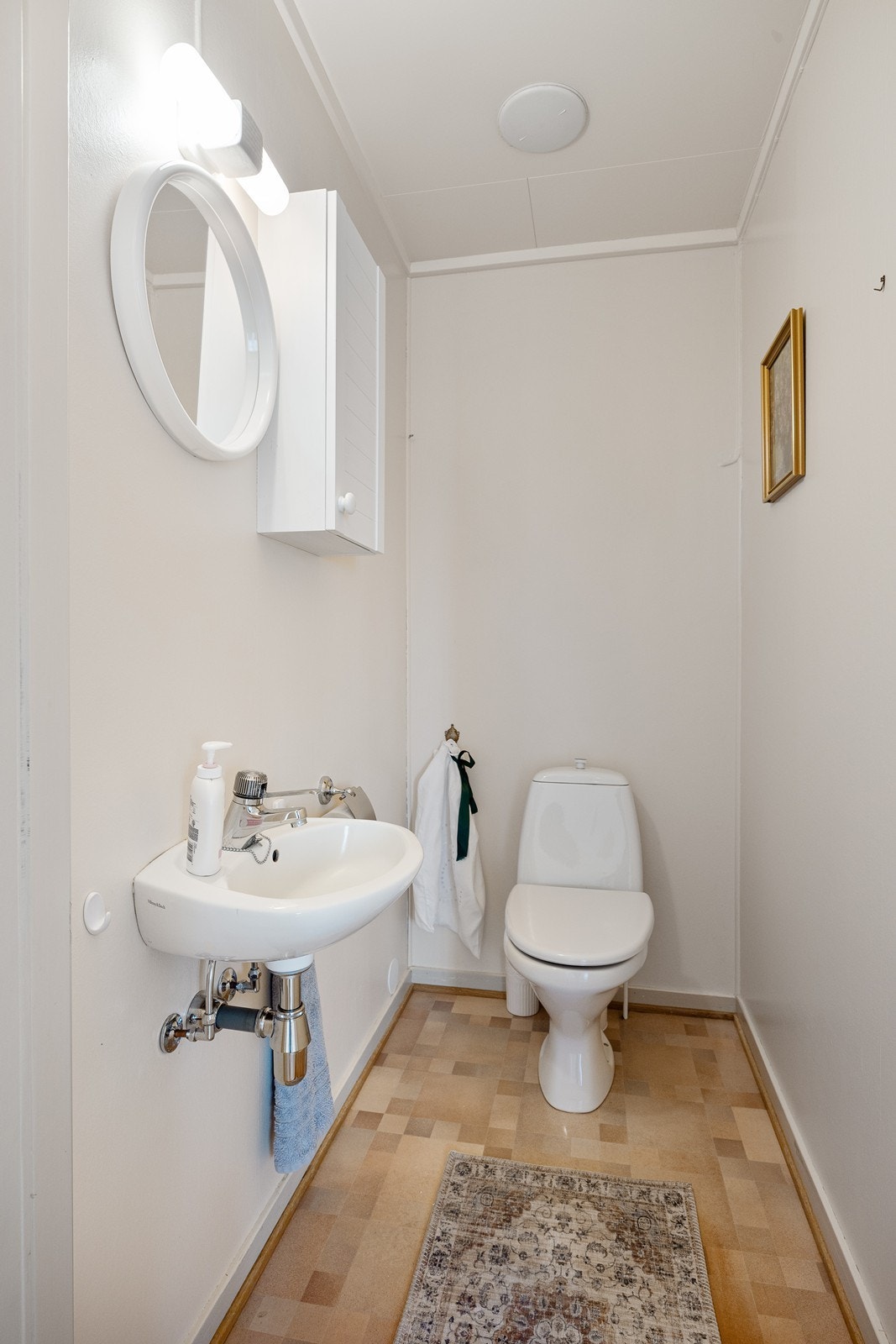 I første etasje har boligen et bad/vaskerom og et separat wc-rom - sistnevnte har enkel servant, veggskap og gulvmontert toalett. Galleribilde