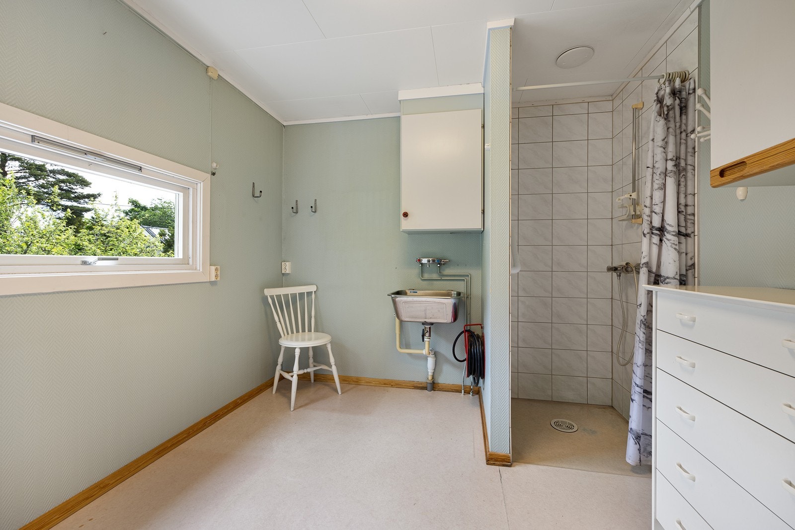 Det kombinerte badet/vaskerommet er av god størrelse og har åpent dusjhjørne, utslagsvask og opplegg for vaskemaskin.
Det finnes også et vaskerom i kjelleretasjen. Galleribilde