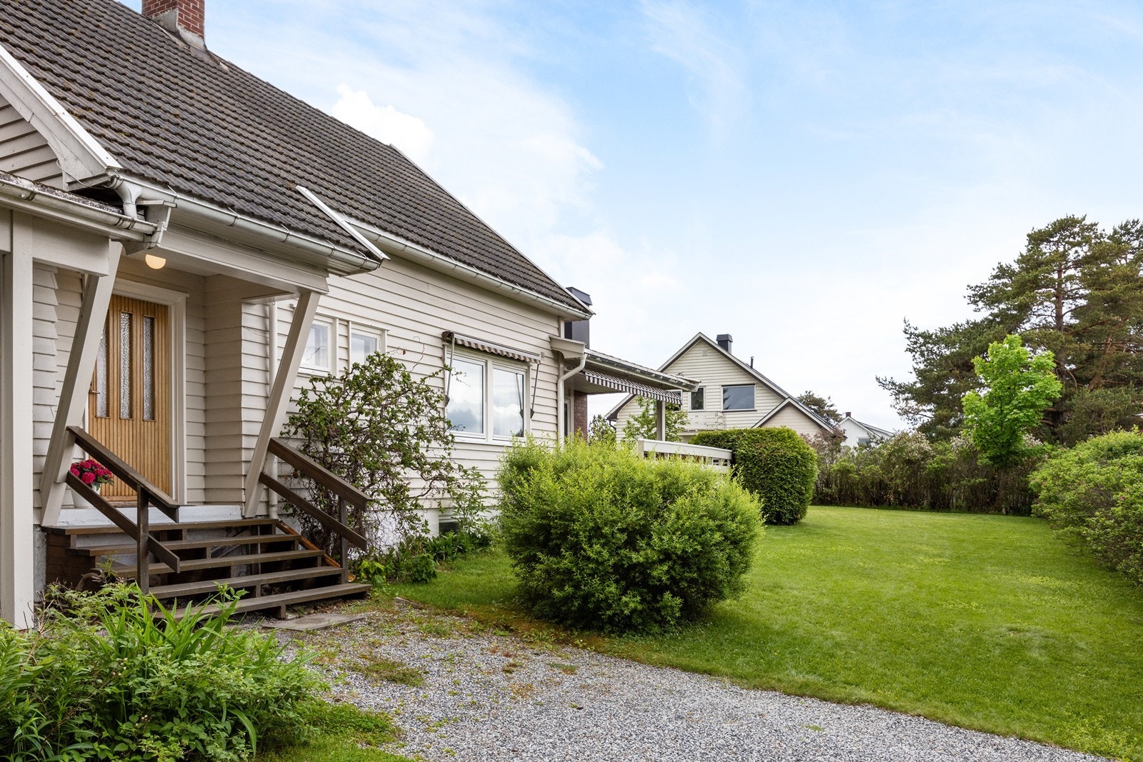 En tretrapp fører opp til det overbygde inngangspartiet. Galleribilde