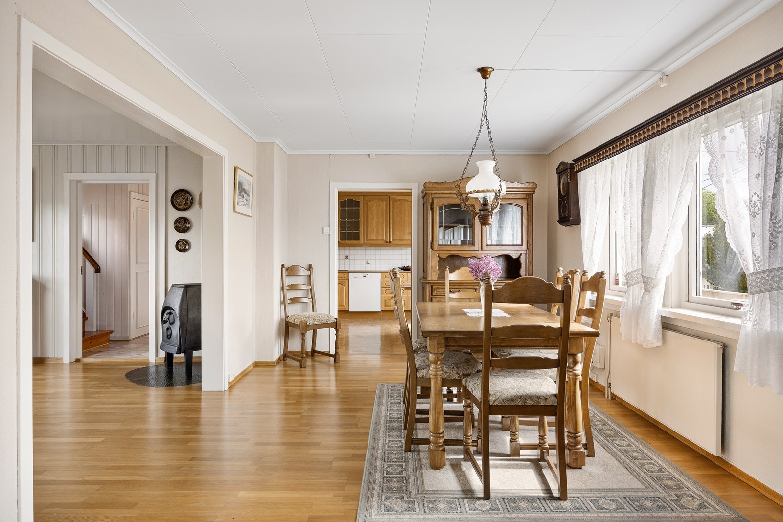 På stuegulvet er det lagt parkett, mens det på veggene er en blanding av lysmalt trepanel og teglstein. Galleribilde