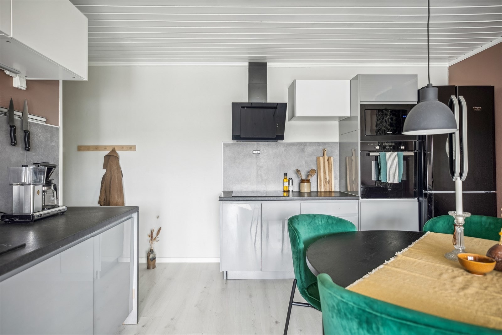 Kjøkkeninnredningen består av benkeplater i laminat, oppvaskkum med avrenningsplate, veggmontert ventilator med kullfilter, plass for vaskemaskin og integrerte hvitevarer. Fliser over benkeskap. Galleribilde