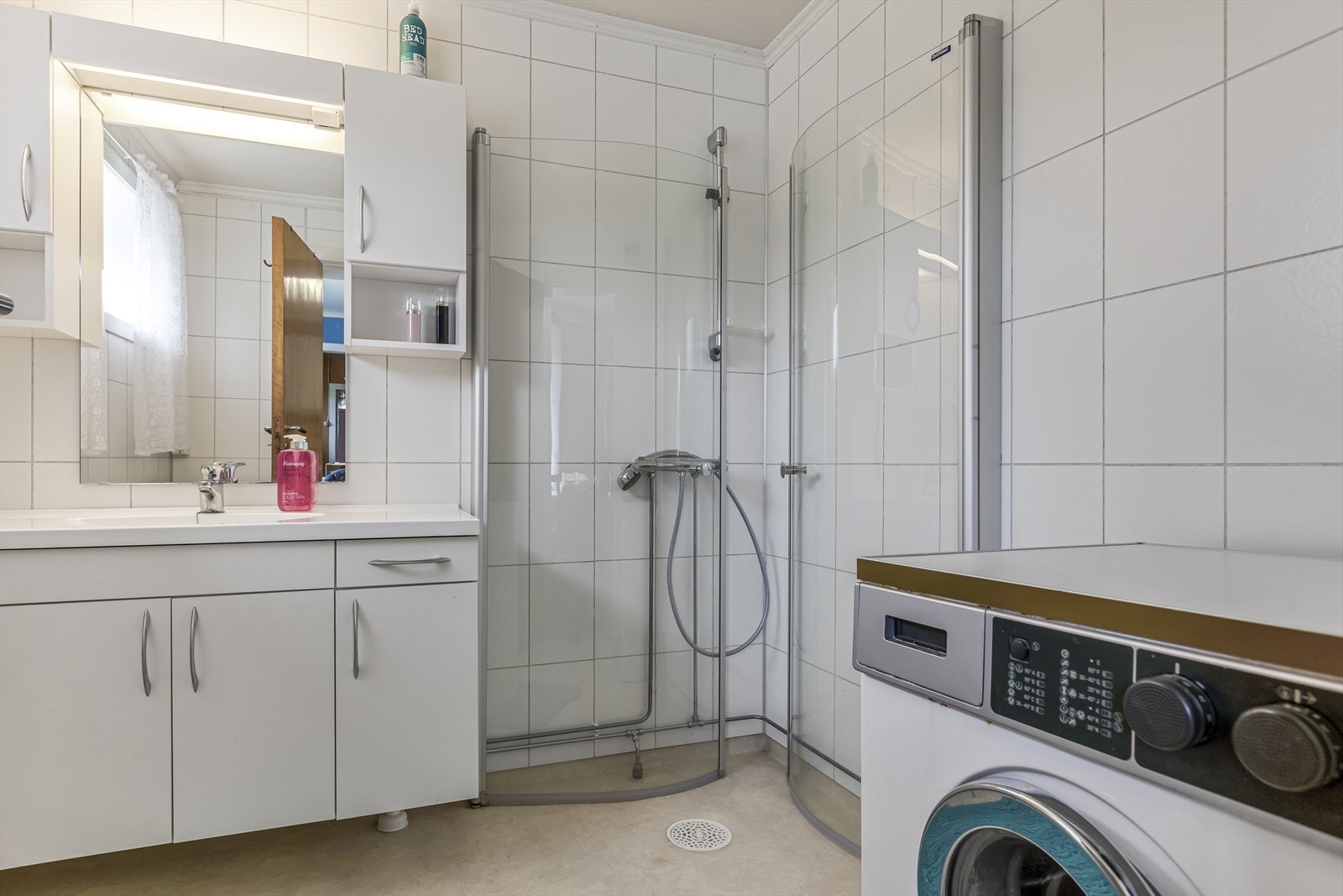Bad med dusjhjørne og opplegg for vaskemaskin Galleribilde