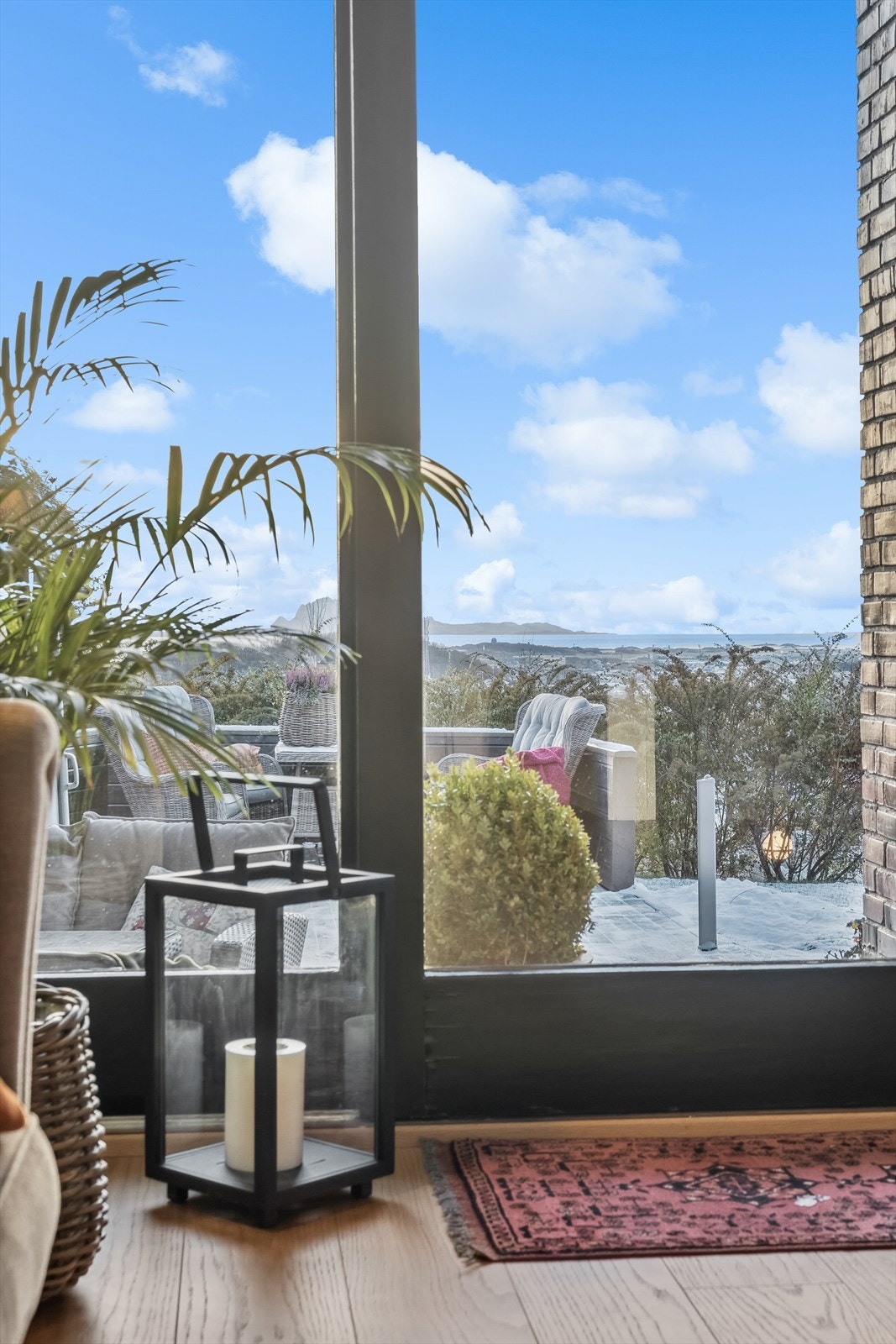 Utgang til en hyggelig vestvendt uteplass med markterrasse og hage Galleribilde