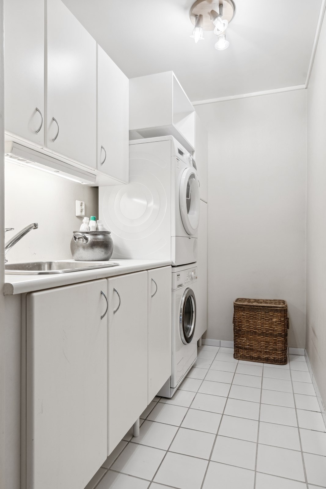 Det er eget vaskerom, slik at du slipper å ha vaskeløsning og skittentøy på badet - Opplegg for vaskemaskin/tørketrommel og innredning med utslagsvask Galleribilde