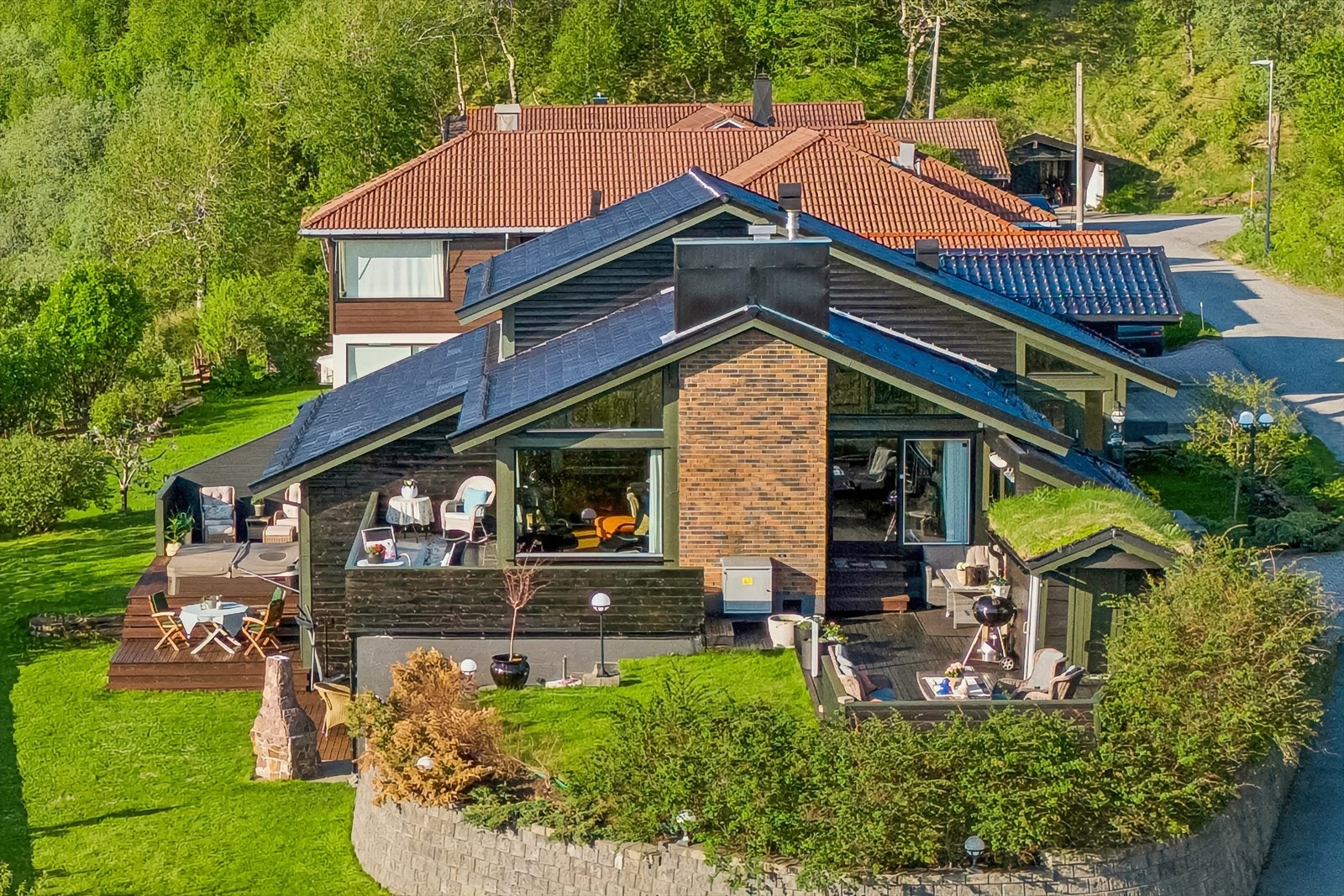 Tomten er romslig med flere fine uteplasser og en stor tilnærmet flat hage Galleribilde