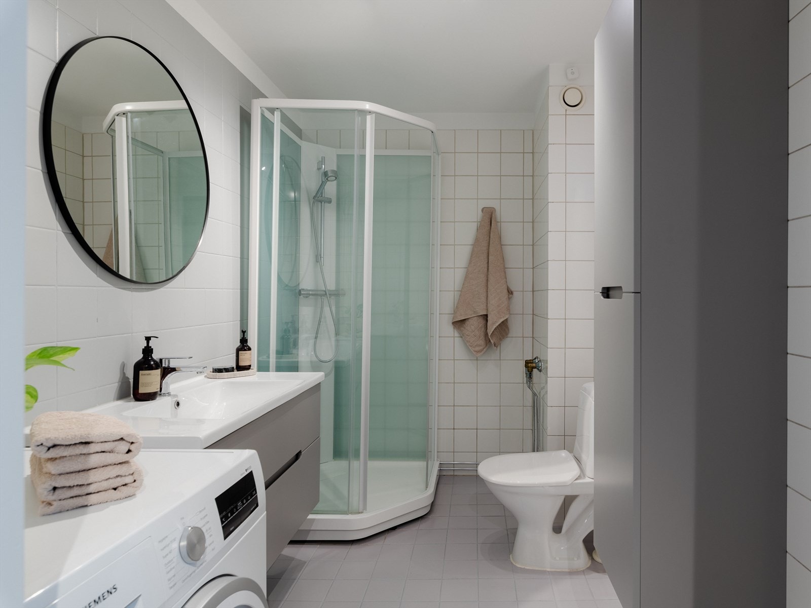 Badet er flislagt med lyse fliser på vegger og gulv. Varmekabler i gulvet holder føttene varme. Galleribilde