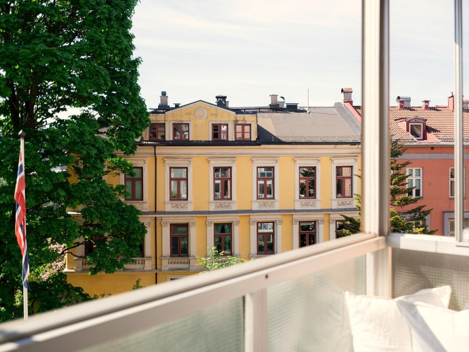 Utsikten fra balkongen er fargerik og frodig, både med vakre gamle bygårder og trær. Galleribilde