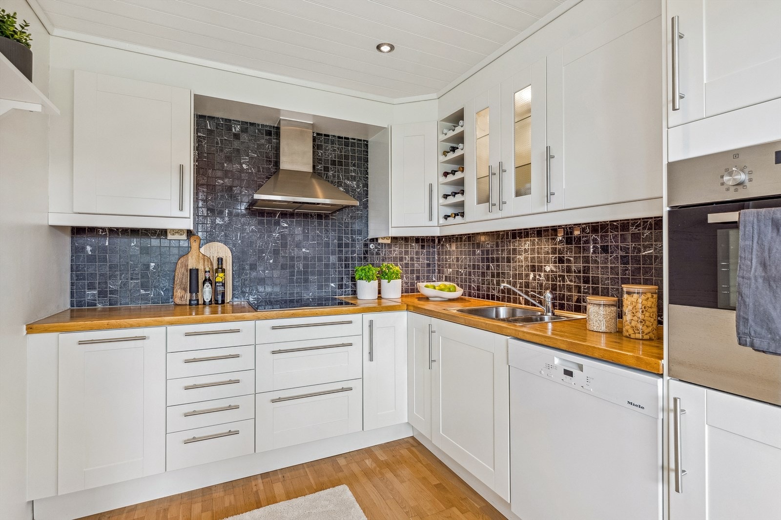 Veggene over benken er kledd med koksgrå fliser som står godt til resten av interiøret. Galleribilde