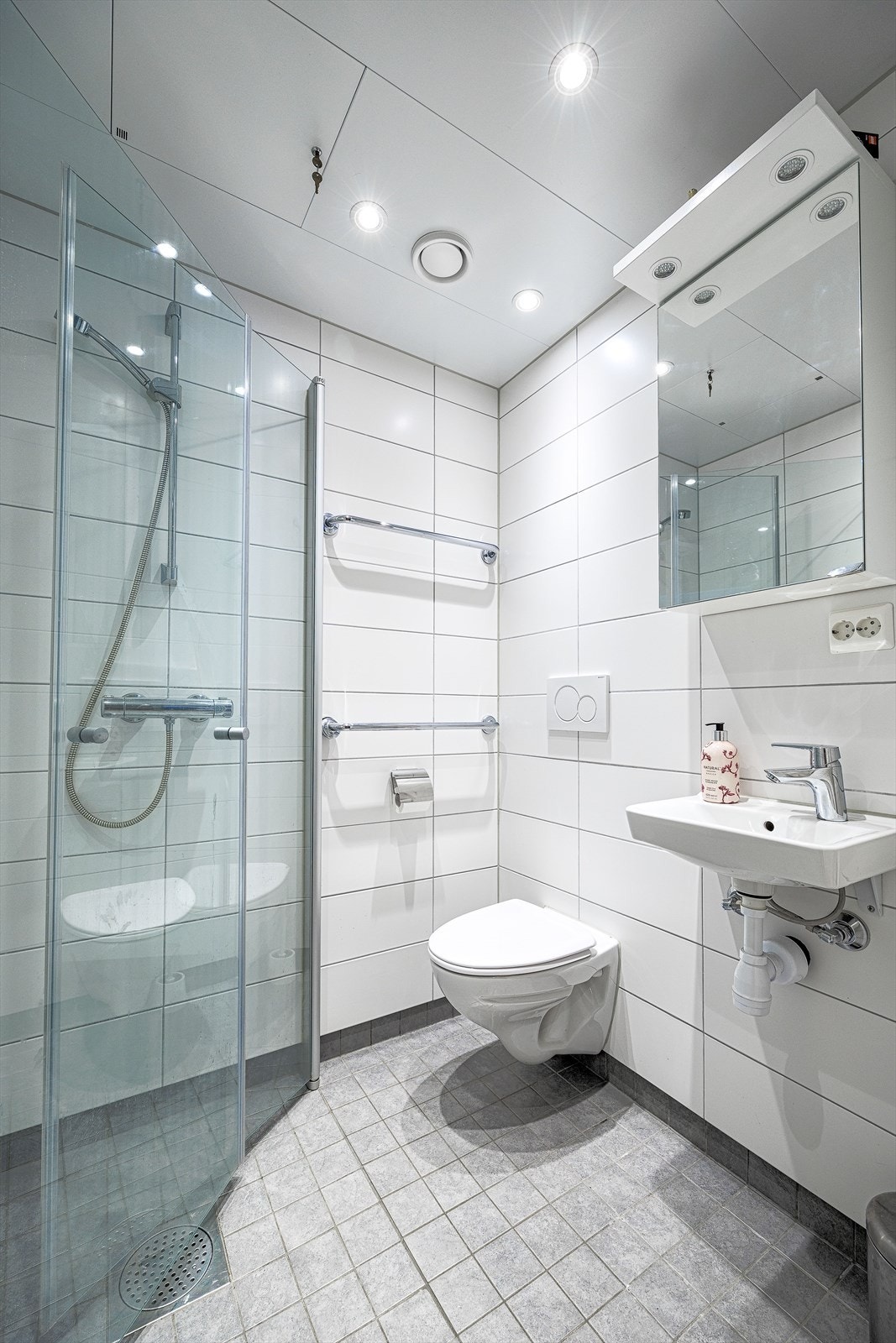 Pent flislagt bad med varmekabler i gulvet og downlights i taket Galleribilde