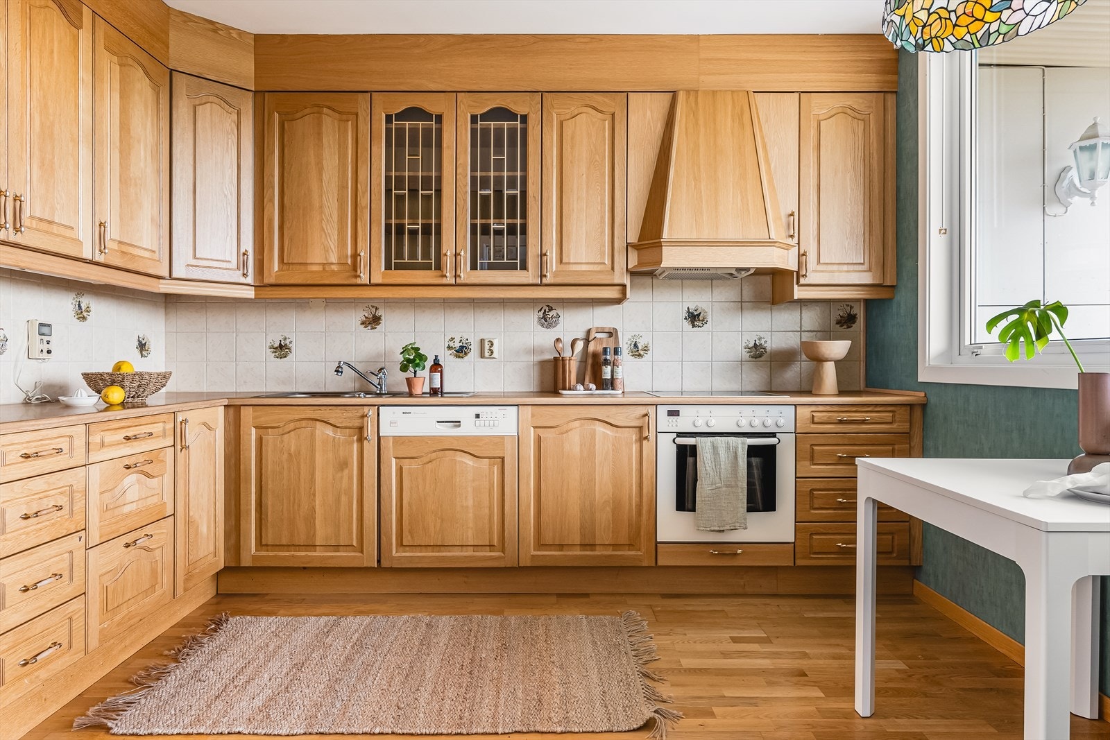 Takhøy kjøkkeninnredning fra 2001 med profilerte eikefronter og ett overskap med glassfronter. Galleribilde