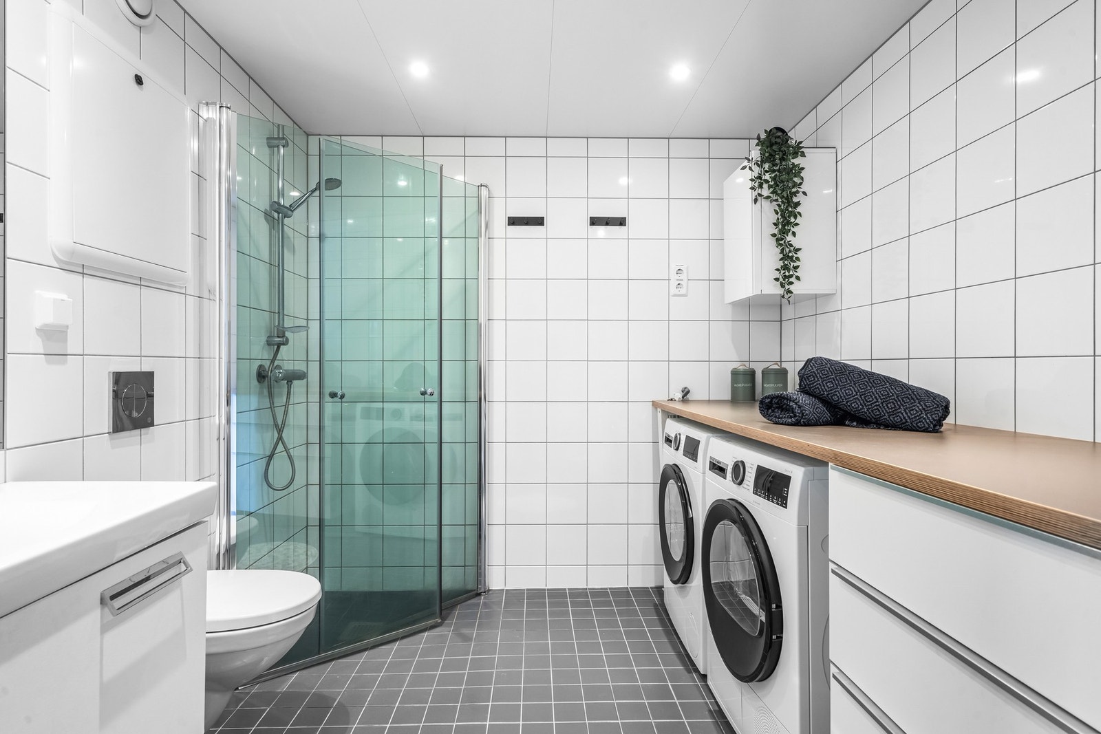 På badet er det opplegg for vaskemaskin og tørketrommel under praktisk benkeplate, som både ekstra oppbevaringsplass og fungerer godt til bretting av tøy. Galleribilde