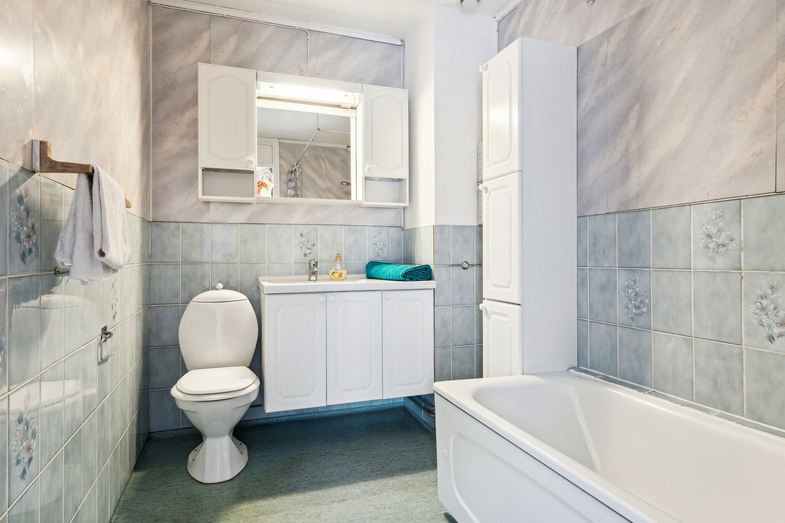 Bad bestående av badekar, mye skapplass og toalett. Galleribilde