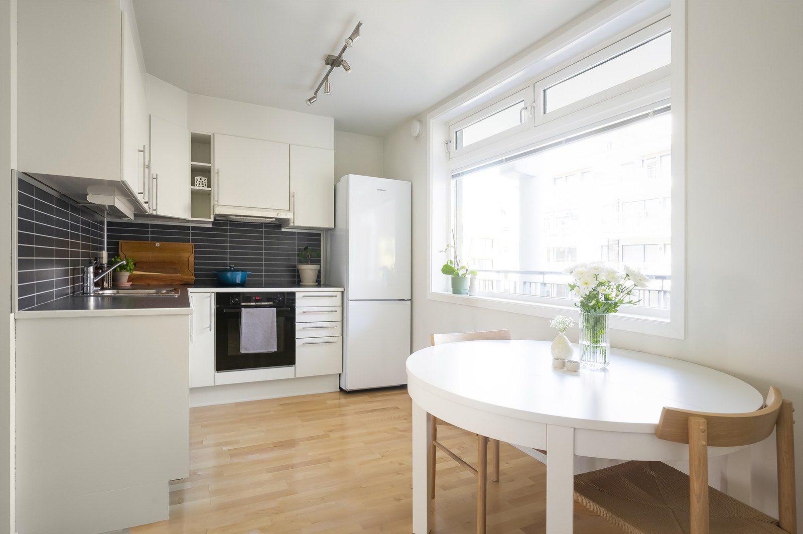Kjøkkeninnredning med glatte fronter, nymalt i 2024, og benkeplate av laminat. Nedfelt oppvaskkum av rustfritt stål og ettgreps armatur. Galleribilde