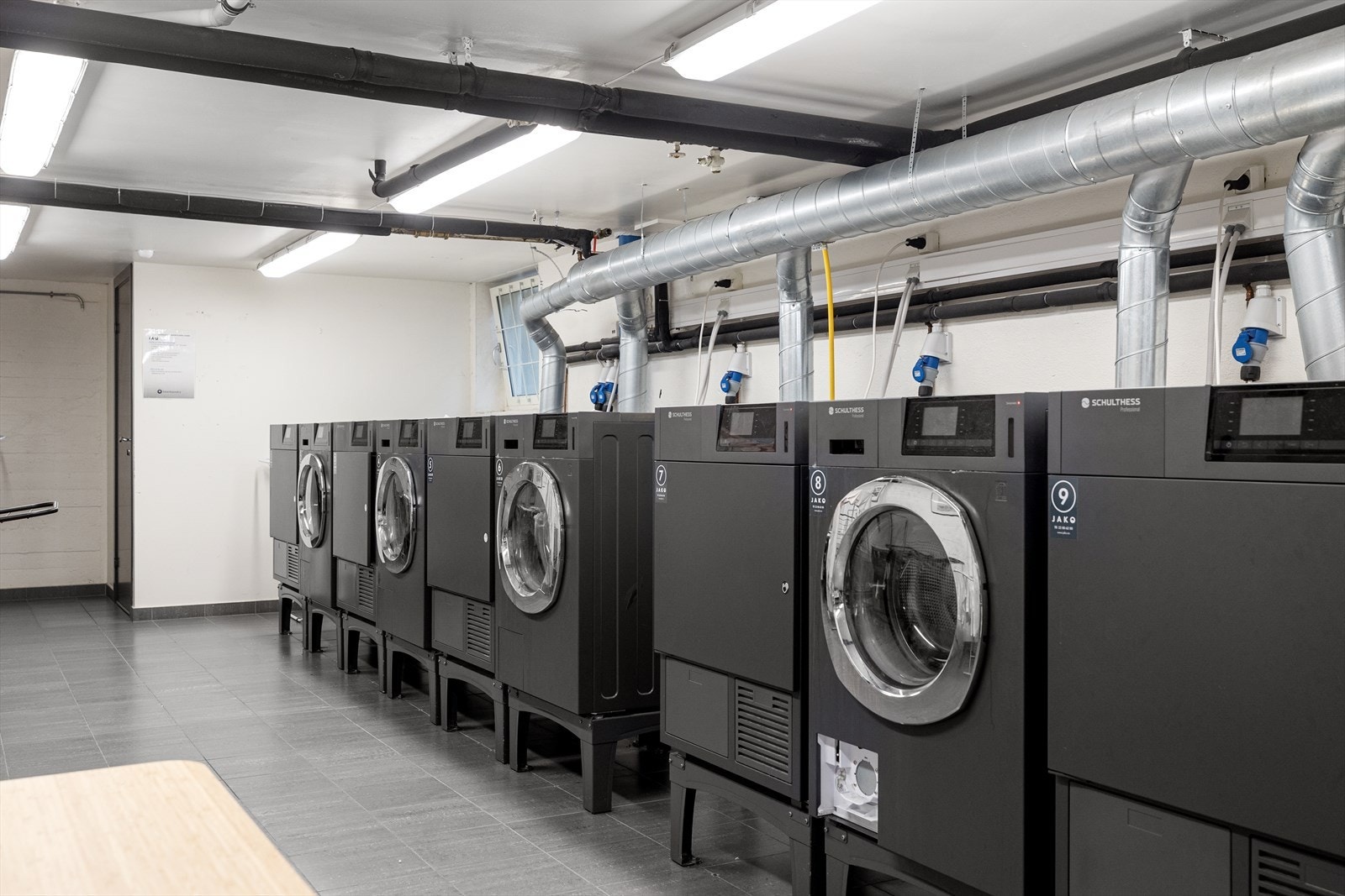 Stort og fint fellesvaskeri med flere vaskemaskiner og tørketromler. Galleribilde
