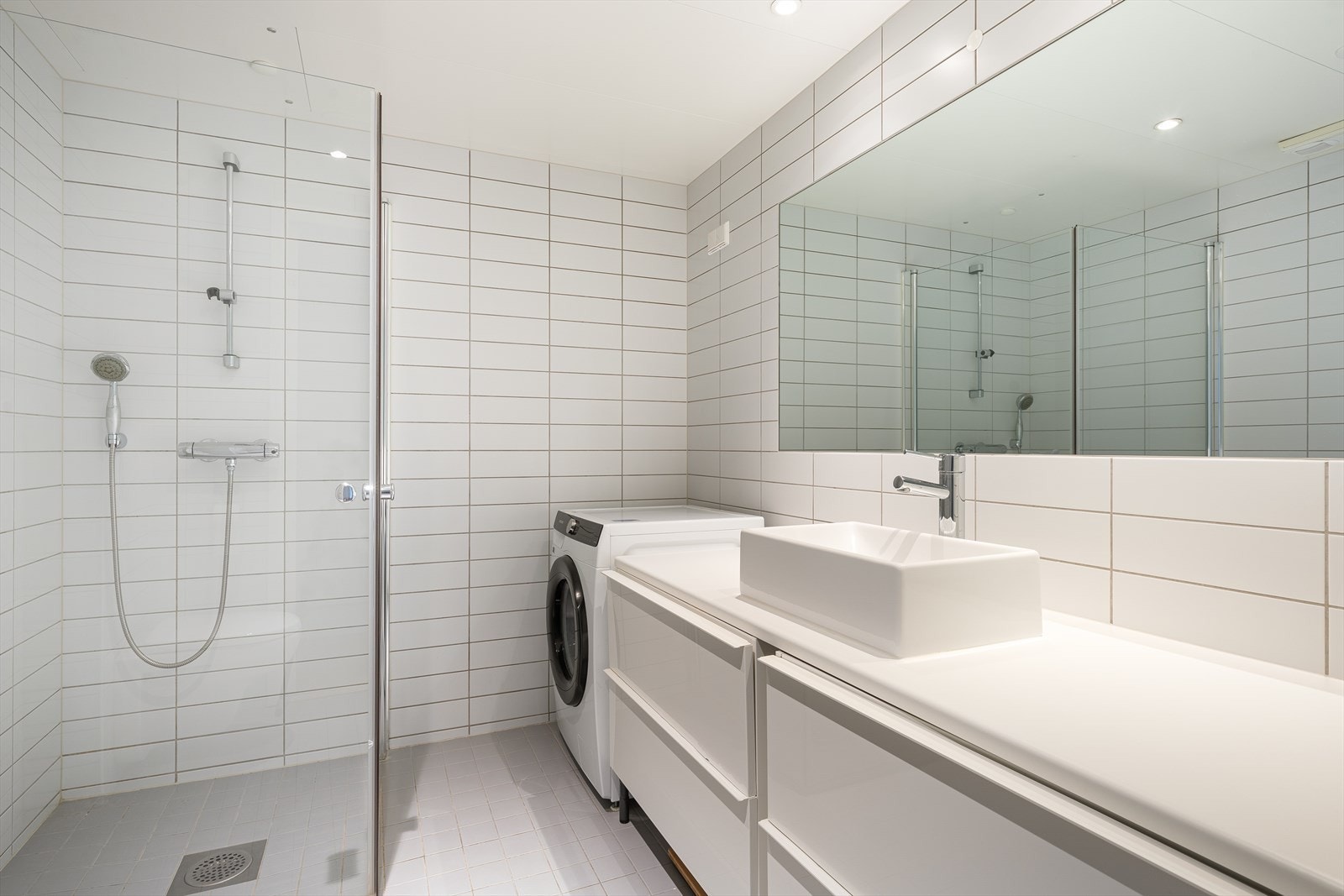 Delikat og flislagt baderom med god plass til oppbevaring i store skuffer under benkeplate. Det er donwlights i tak og gulvvarme på badet som gir en lun og behagelig atmosfære. Galleribilde