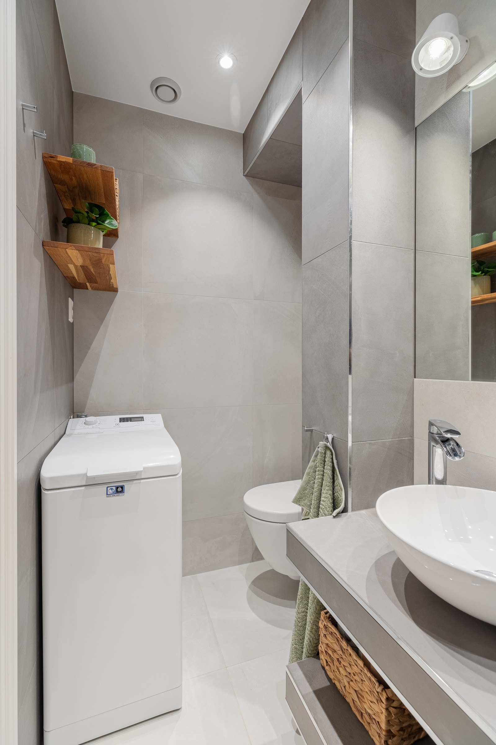 Badet er arealeffektivt med plass til dusjnisje, servant, toalett, vaskemaskin og hyller Galleribilde